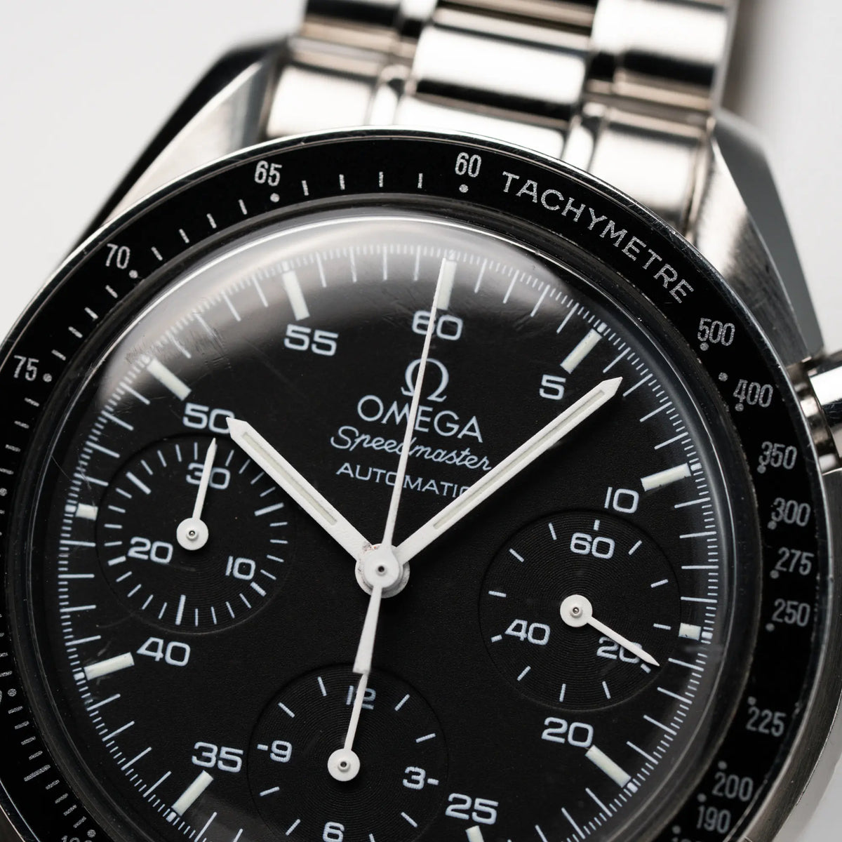 Detailaufnahme des schwarzen Zifferblatts mit weißen Indizes der Omega Speedmaster Reduced