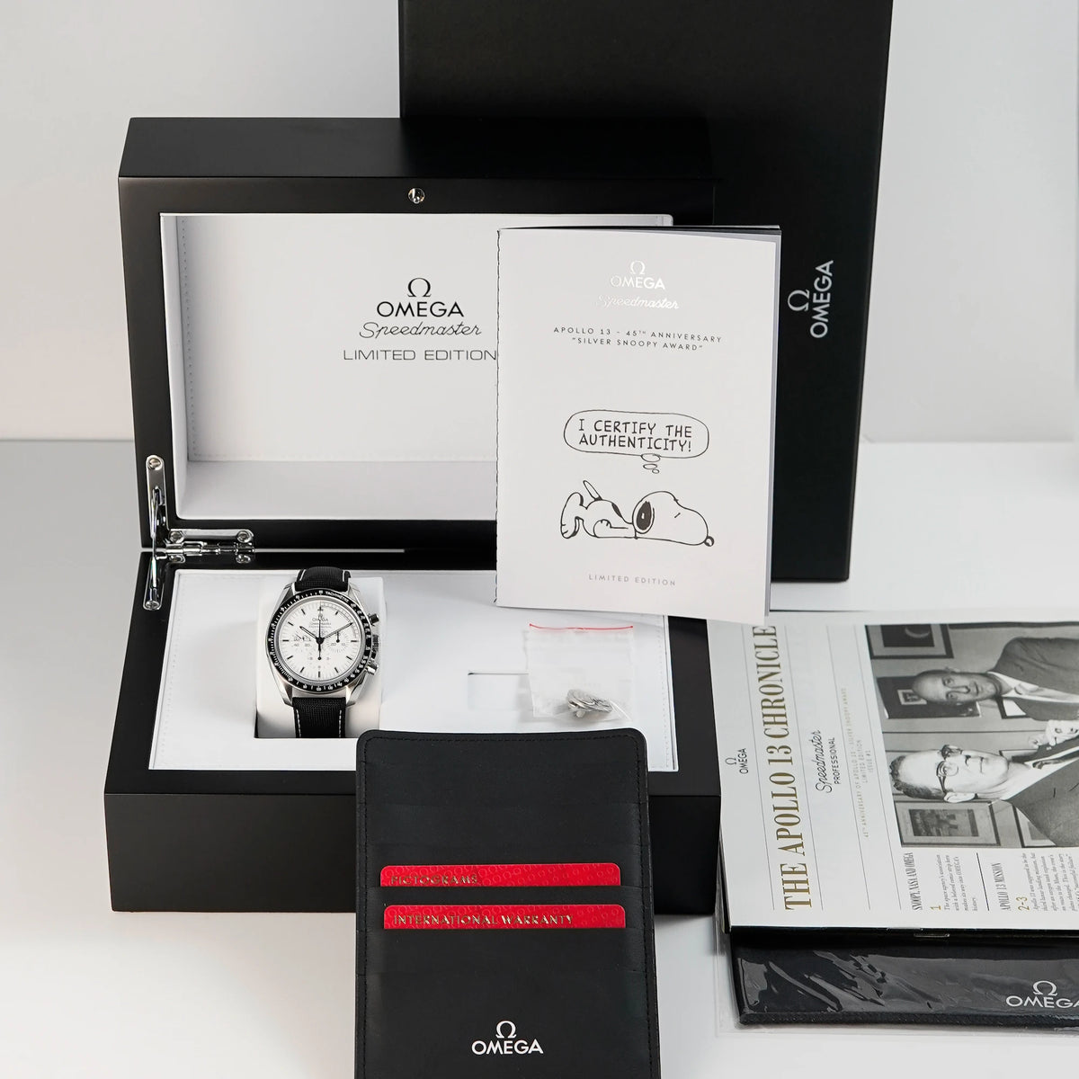 Omega Speedmaster Moonwatch Silver Snoopy mit dem weißen Zifferblatt zusammen mit dem Lieferumfang, bestehend aus Box, Papieren, einem Snoppy-Pin, sowie allen Booklets - absolutes Full-Set