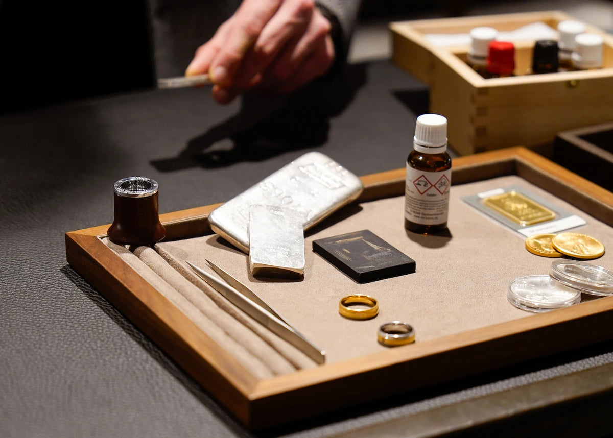 Der zu verkaufende Schmuck, das Gold und Silber liegen auf einem Tablet, während der Ankäufer die Wertgegenstände prüft