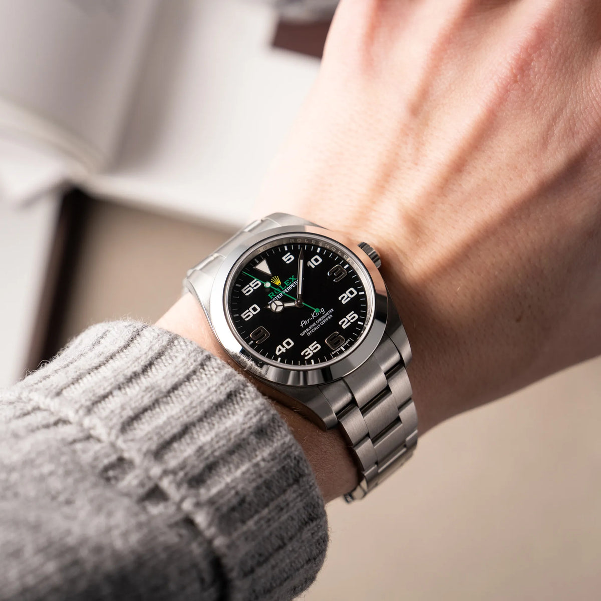 Mann trägt die Rolex Oyster Perpetual Air King 116900 mit 40mm Gehäuse und dem klassischen schwarzen Zifferblatt mit grünem Sekundenzeiger für einen Wristshot an seinem Handgelenk
