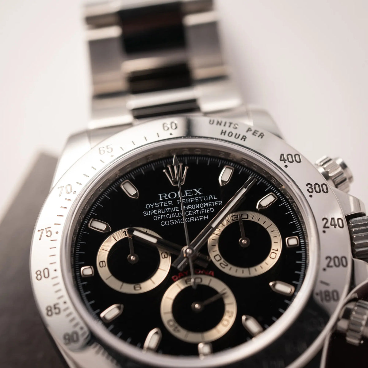 Detailaufnahme des Uhrengehäuses von der Rolex Cosmograph Daytona 116520 mit schwarzem Zifferblatt und der klassischen Edelstahl-Lünette vor Umstellung auf die Keramik-Lünette