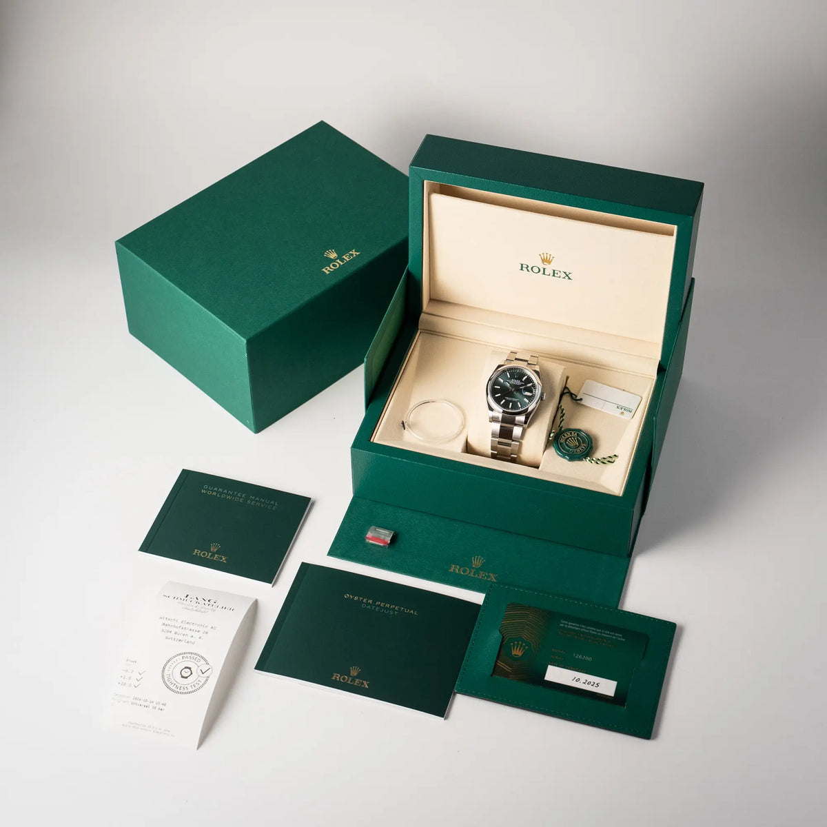 Lieferumfang zu der mit Stickern teil-verklebte Rolex Datejust 36 der Referenz 126200 mit glatter Lünette am Oyster-Stahlband mit dem Mint-Green-Zifferblatt , betsehend aus Box mit Umkarton, Booklets, originaler Garantiekarte, Wasserdichtheitstest, Hangtag