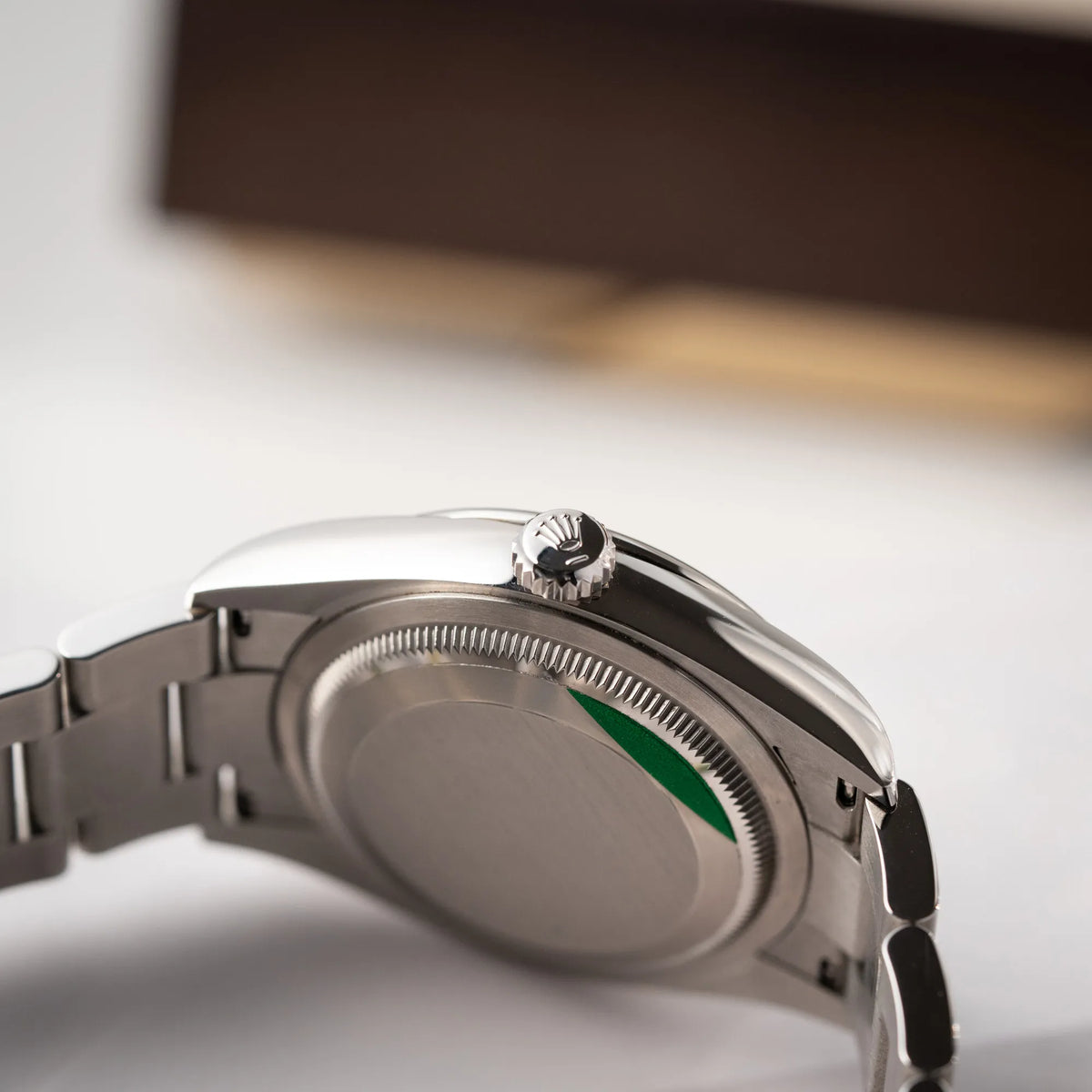 Produktfotografie der mit Stickern teil-verklebte Rolex Datejust 36 der Referenz 126200 mit glatter Lünette am Oyster-Stahlband mit dem Mint-Green-Zifferblatt zeugt die Aufzugskrone und den verklebten Gehäuseboden