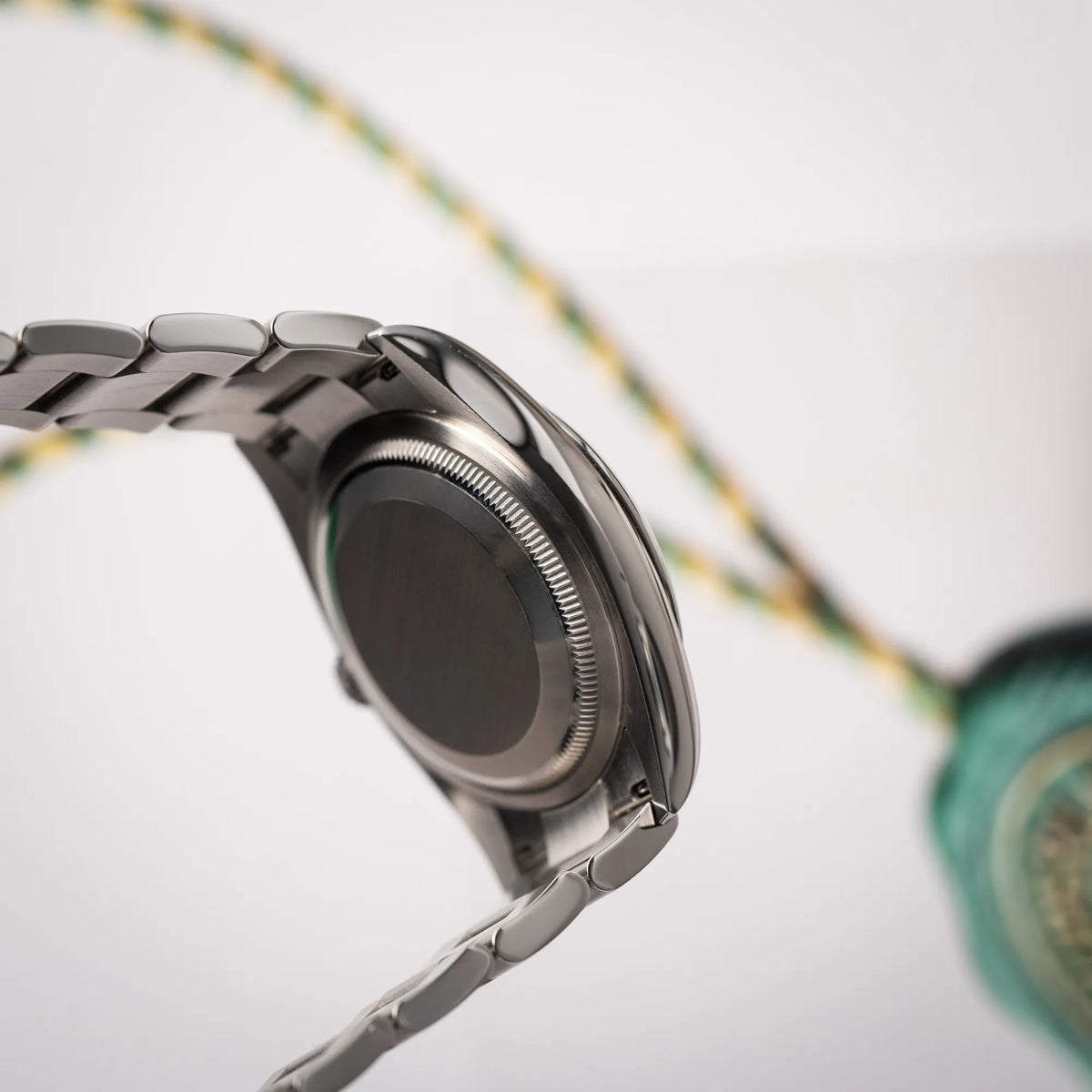 Seitliche Gehäuseflanke der mit Stickern teil-verklebte Rolex Datejust 36 der Referenz 126200 mit glatter Lünette am Oyster-Stahlband mit dem Mint-Green-Zifferblatt