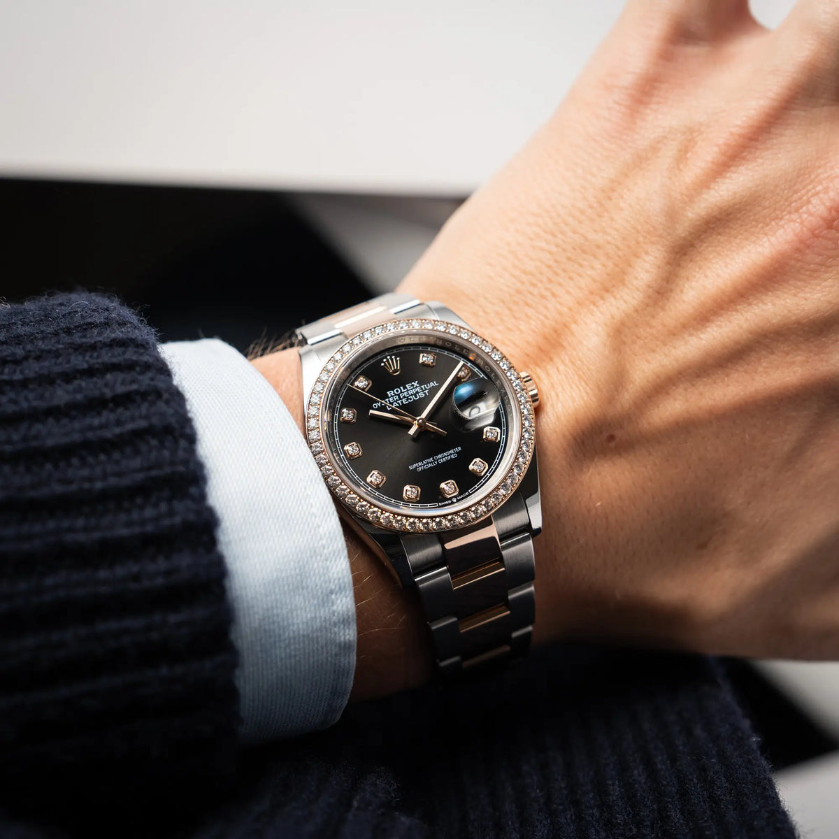Mann trägt die Rolex Datejust 36 126218RBR in Stahl-Roségold mit schwarzem Diamant-Zifferblatt und Diamant-Lünette im Factory-Besatz an seinem Handgelenk