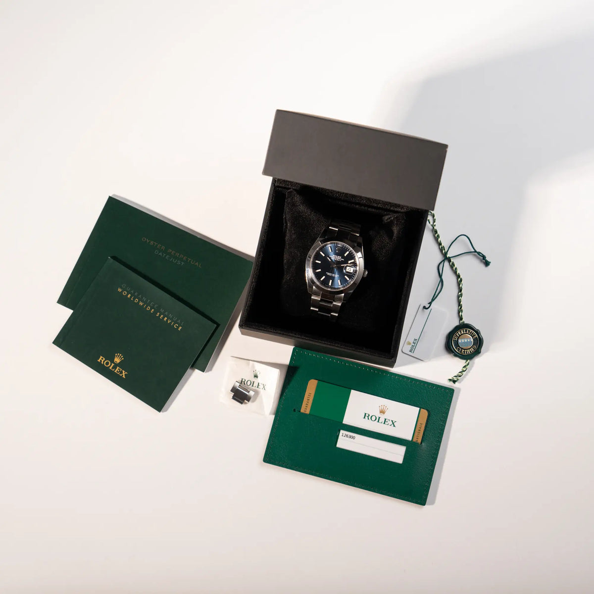 Rolex Datejust 41 der Referenz 126300 mit blauem Zifferblatt, glatter Lünette, am Oyster-Stahlband zusammen mit dem Lieferumfang, bestehend aus Uhr, Hangtag, Booklets, der Garantiekarte und einer neutralen Uhrenbox