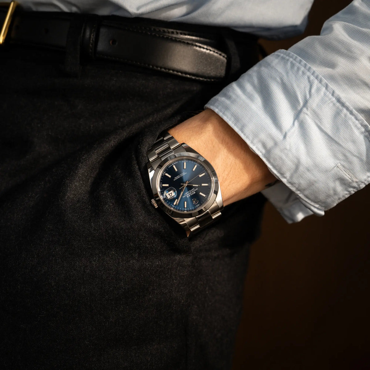 Mann im Anzug trägt die Rolex Datejust 41 der Referenz 126300 mit blauem Zifferblatt, glatter Lünette, am Oyster-Stahlband