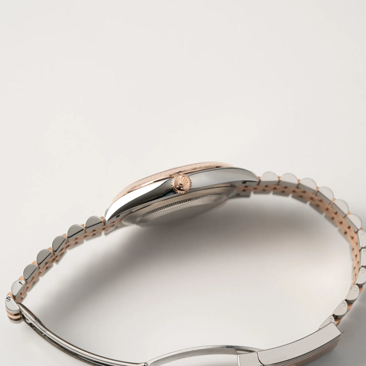 Seitliche Gehäuseflanke mit Blick auf die rosegoldene Aufzugskrone der Rolex Datejust 41 in Stahl-Roségold mit am passenden Jubilee-Armband mit dem pink-lachsfarbenen "Sundust" Zifferblatt