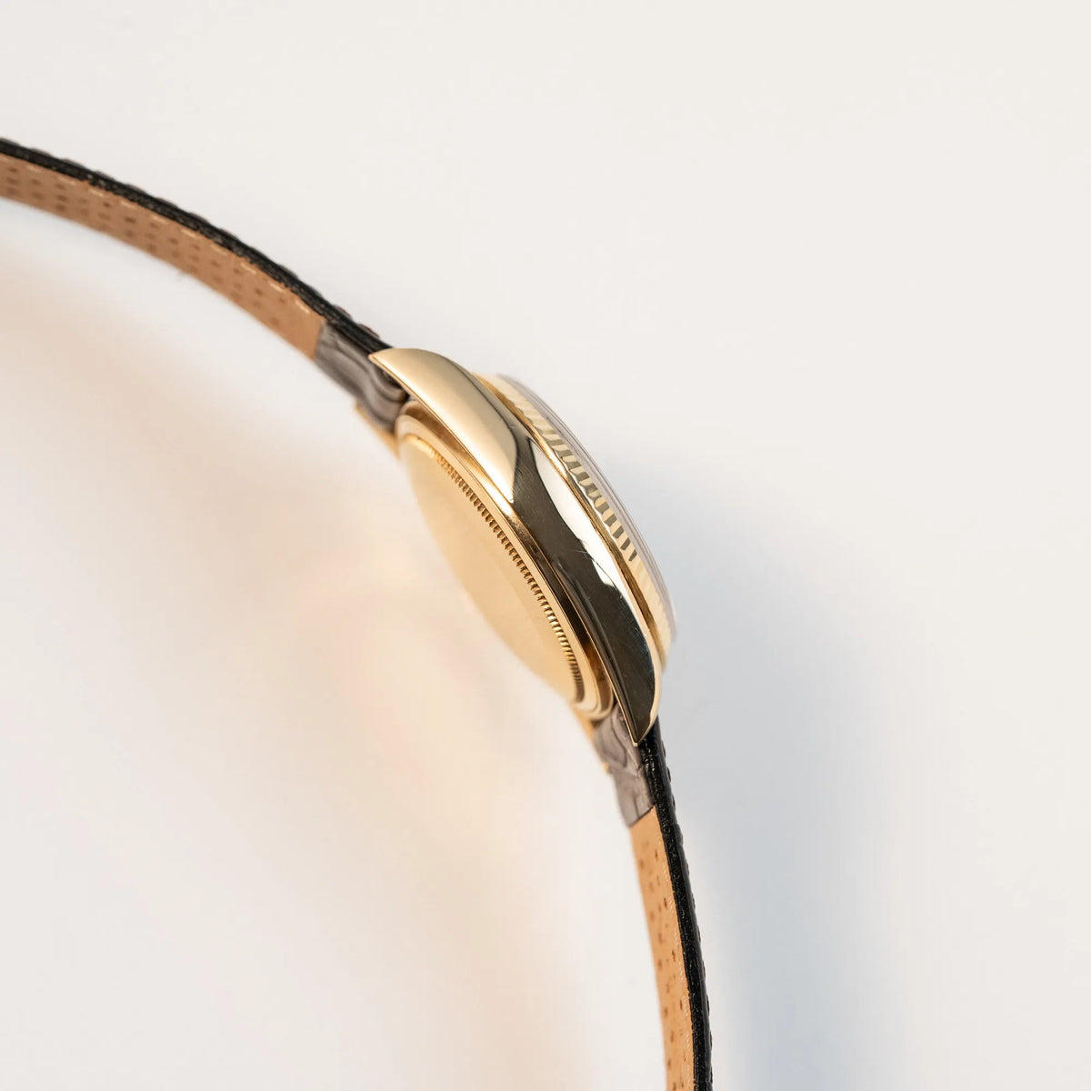 Seitliches Gehäuse der Rolex Day-Date 36 der Referenz 18038 in Gelbgold mit blauem Zifferblatt am braunen Lederband