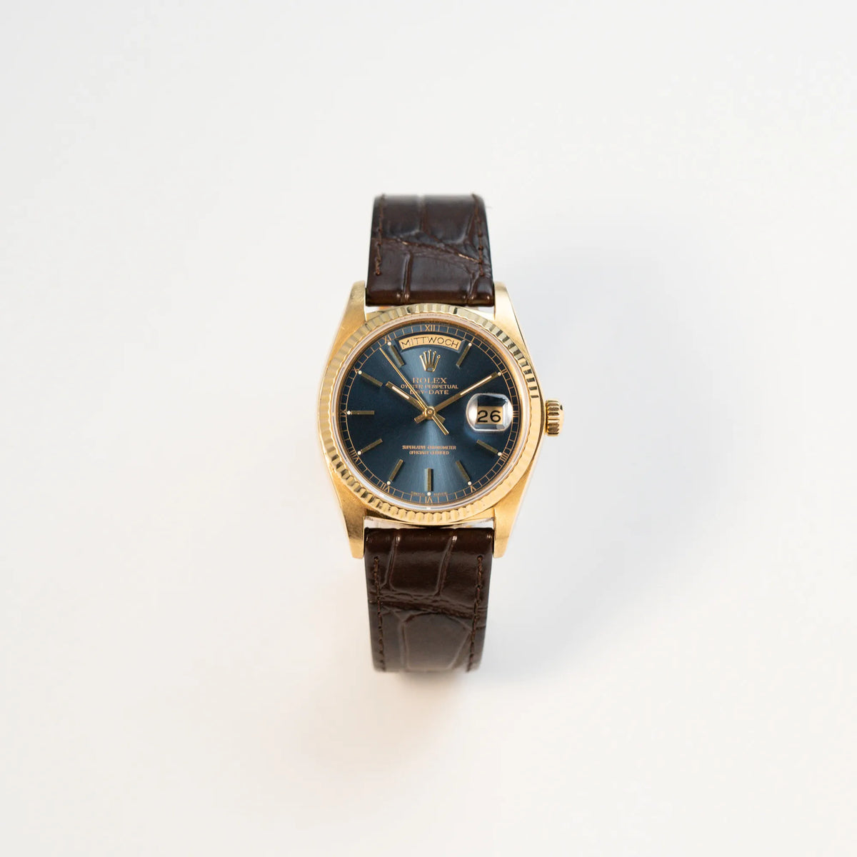 Frontale Ansicht der Rolex Day-Date 36 der Referenz 18038 in Gelbgold mit blauem Zifferblatt am braunen Lederband