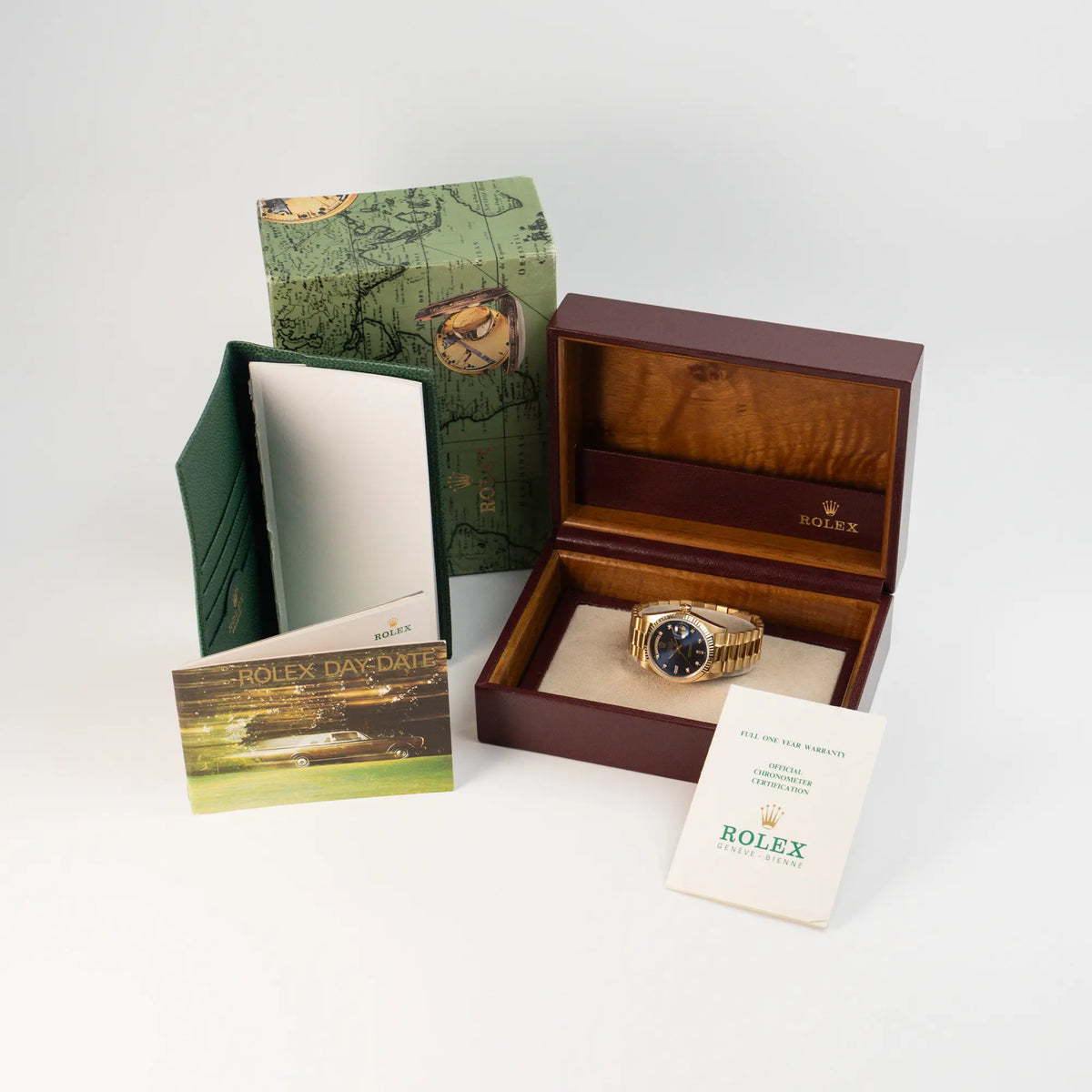 Rolex Day-Date 36 (Referenz: 18038) in Gelbgold mit blauem Diamant-Zifferblatt zusammen mit dem Lieferumfang bestehend aus Uhr, originaler brauner Rolex-Box, das zugehörige Booklet, die originalen Papiere und eine grüne Rolex Ledermappe