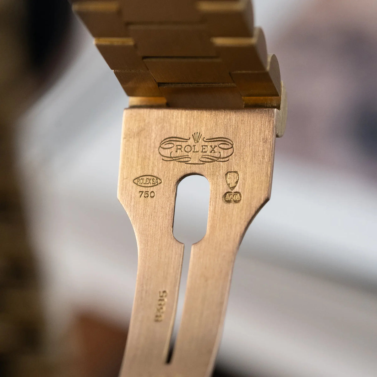 Detailaufnahme des klassischen Rolex Logos und der Prägestempel im Gelbgold-Band der Rolex Day-Date 36 (Referenz: 18038) in Gelbgold mit blauem Diamant-Zifferblatt