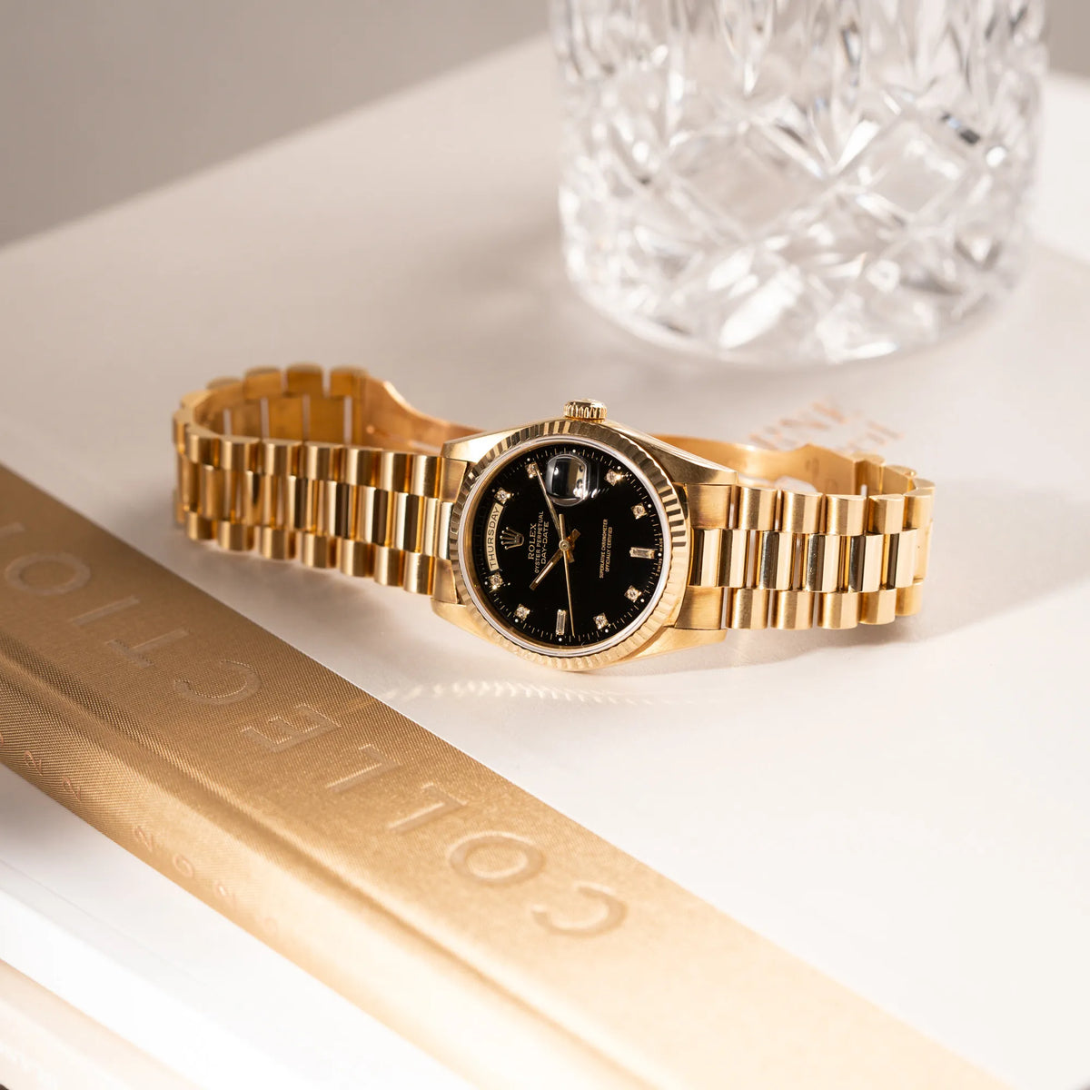 Produktfotografie der Rolex Day-Date 36 in Gelbgold mit der Referenznummer 18238 mit englisches Tagesanzeige, mit schwarzem Lack-Zifferblatt und Diamant-Indizes