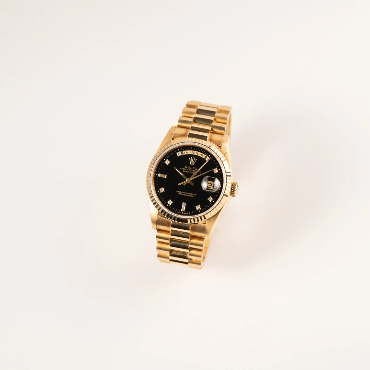 Leicht schräge Ansicht der Rolex Day-Date 36 mit der Referenznummer 18238 mit englisches Tagesanzeige, mit schwarzem Lack-Zifferblatt und Diamant-Indizes