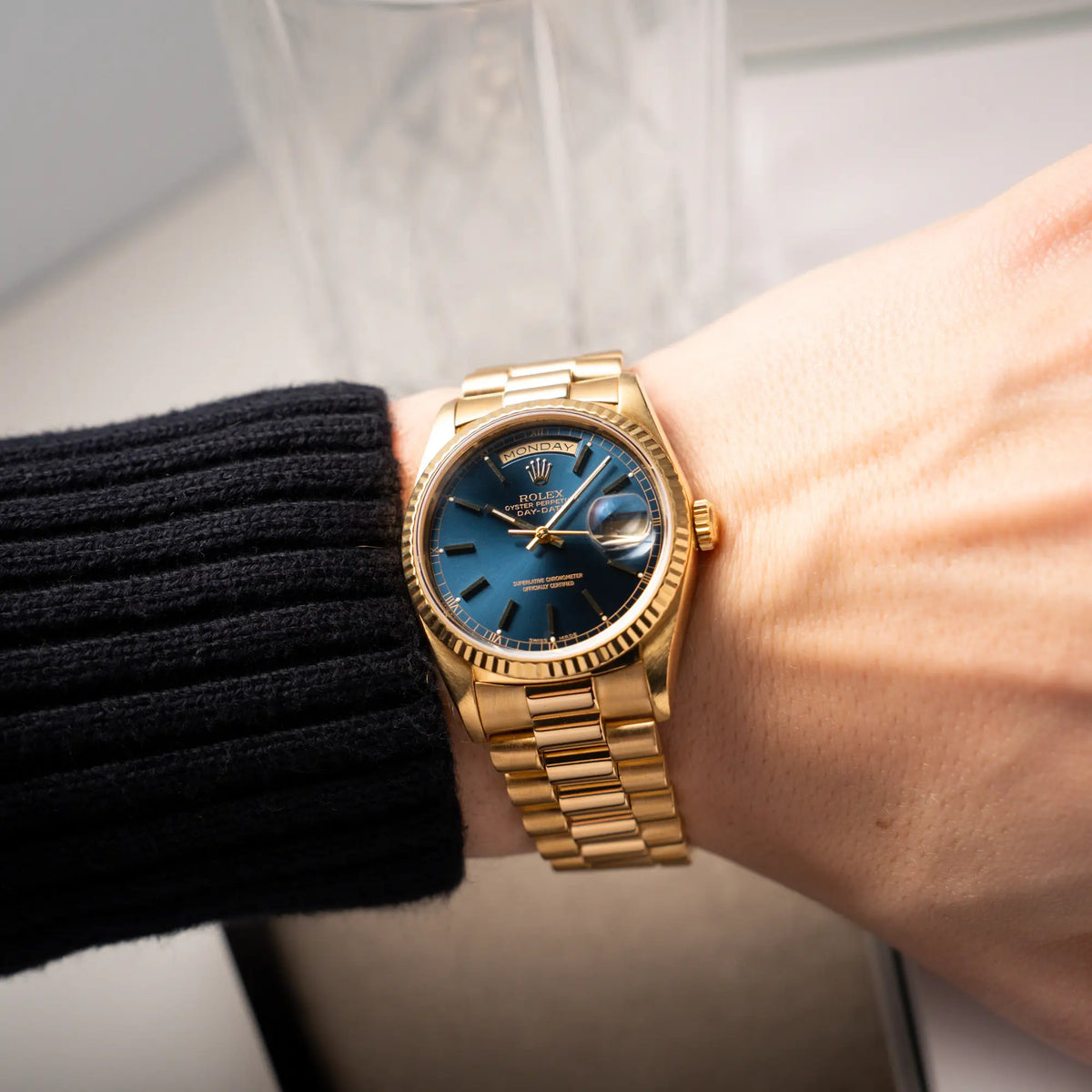 Wristshot mit der gelbgoldenen Rolex Day-Date 36 der Referenz 18238 mit blauem Zifferblatt und englisch-sprachiger Tagesanzeige