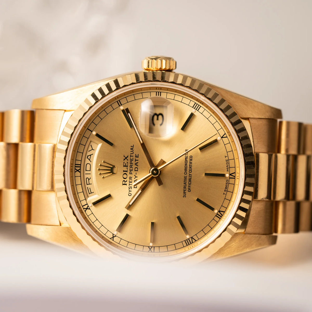 Detailaufnahme des Uhrenkopfes von der Rolex Day-Date 36 der Referenz 18238 in Gelbgold mit champagnerfarbenem Stick-Dial