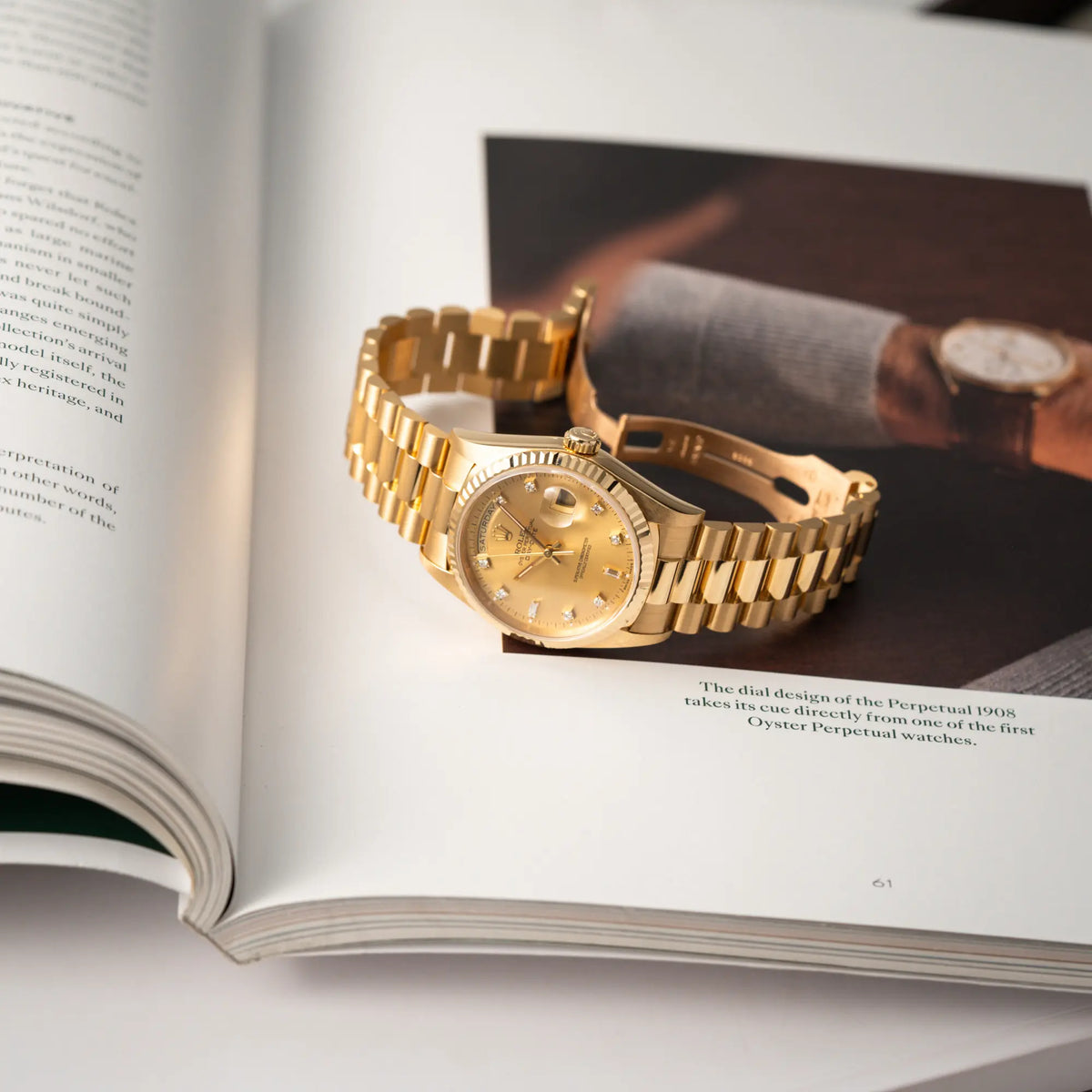 Rolex Day-Date 36 aus 1991 der Referenz 18238 mit goldfarbenem Zifferblatt und Diamant Indizes in einem hervorragenden Gesamtzustand liegt auf einem Buch über Armbanduhren