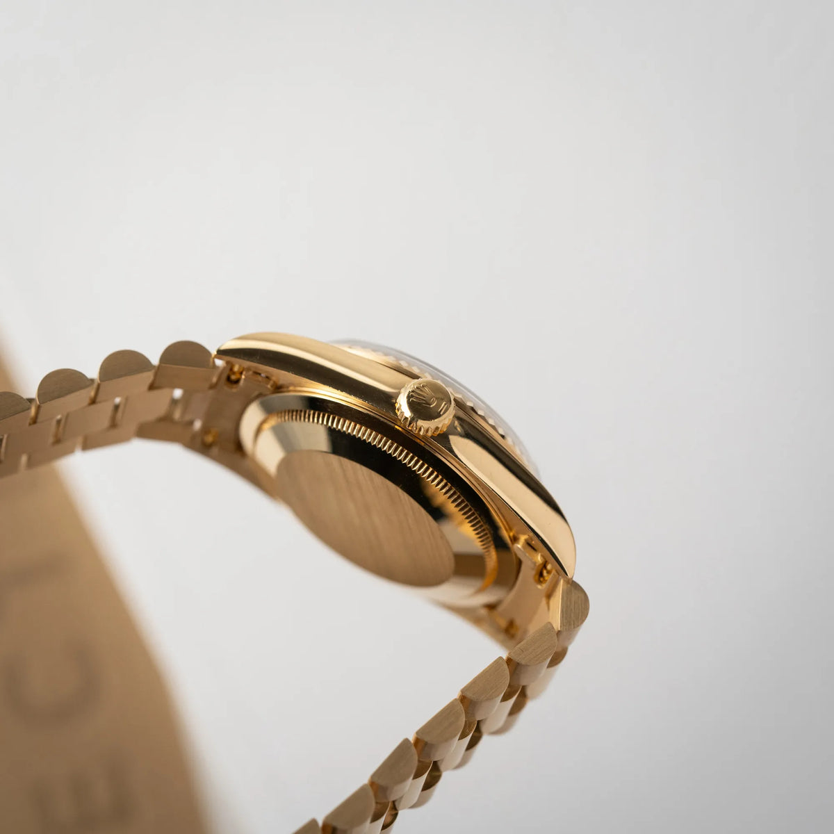 Seitliche Gehäuseflanke mit Blick auf die Aufzugskrone der Rolex Day-Date 36 der Referenz 18238 in Gelbgold mit schwarzen Diamond-Dial am President-Armband