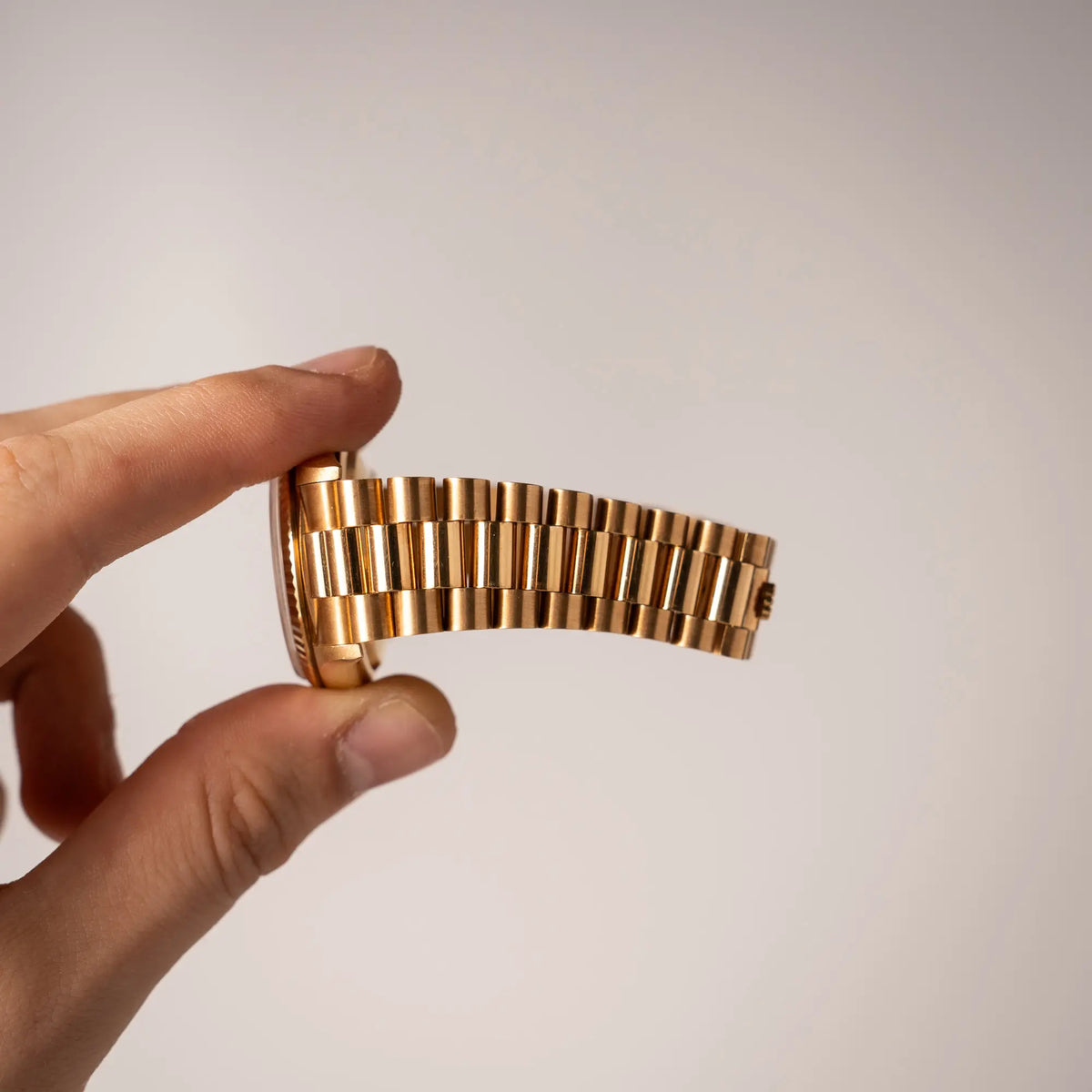 Mann hält die gelbgoldene Rolex Day-Date 36 der Referenz 18238 mit einem seltenen Myriad-Dial mit Diamant-Kranz und römischen Indizes in seiner Hand und zeigt den kaum vorhanden Stretch des President-Armband