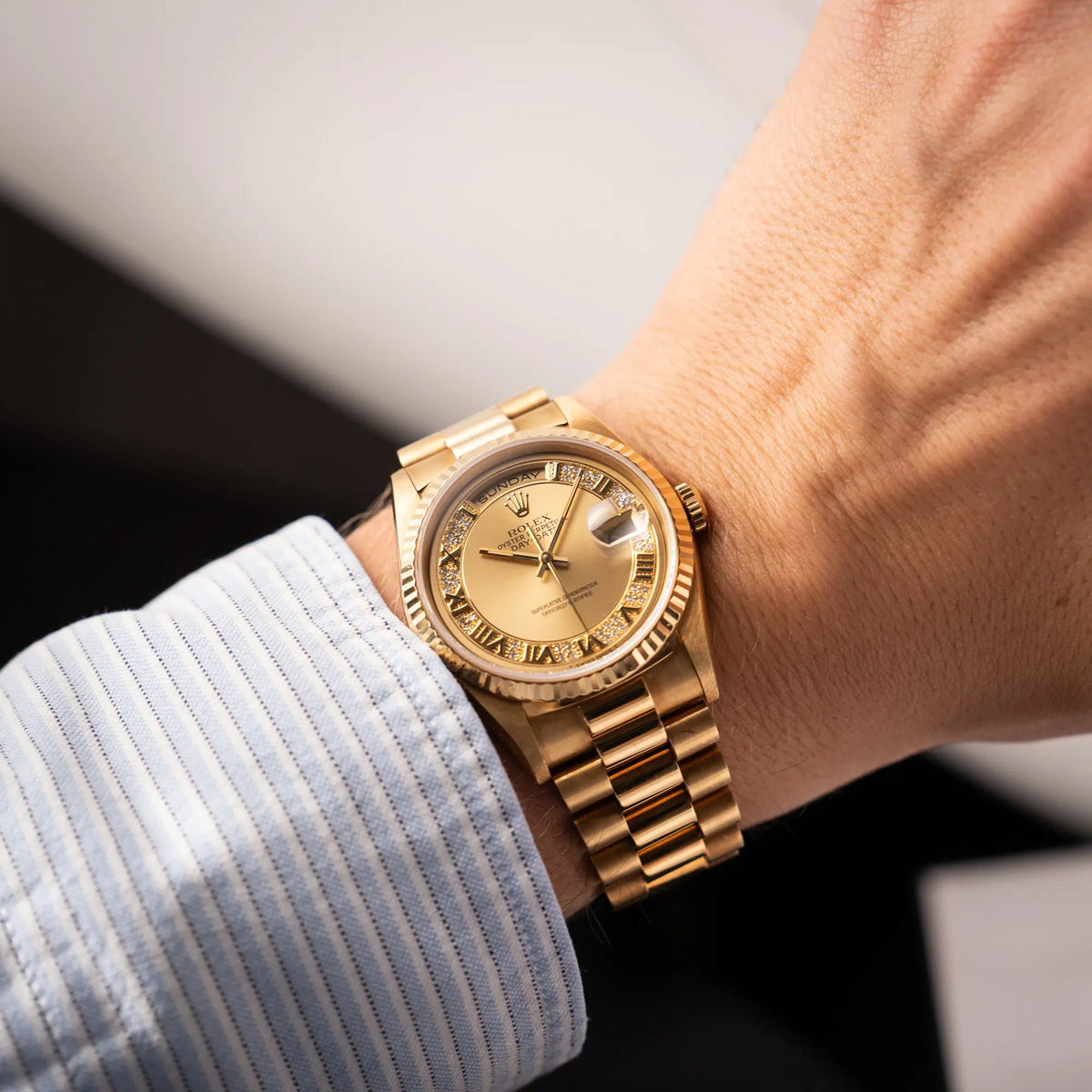 Mann trägt die gelbgoldene Rolex Day-Date 36 der Referenz 18238 mit einem seltenen Myriad-Dial mit Diamant-Kranz und römischen Indizes an seinem Handgelenk