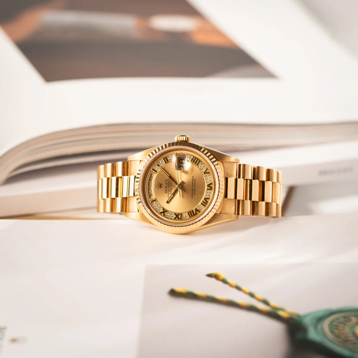 der gelbgoldenen Rolex Day-Date 36 der Referenz 18238 mit einem seltenen Myriad-Dial mit Diamant-Kranz und römischen Indizes liegt seitlich auf der Gehäuseflanke auf dem Rolex-Magazin