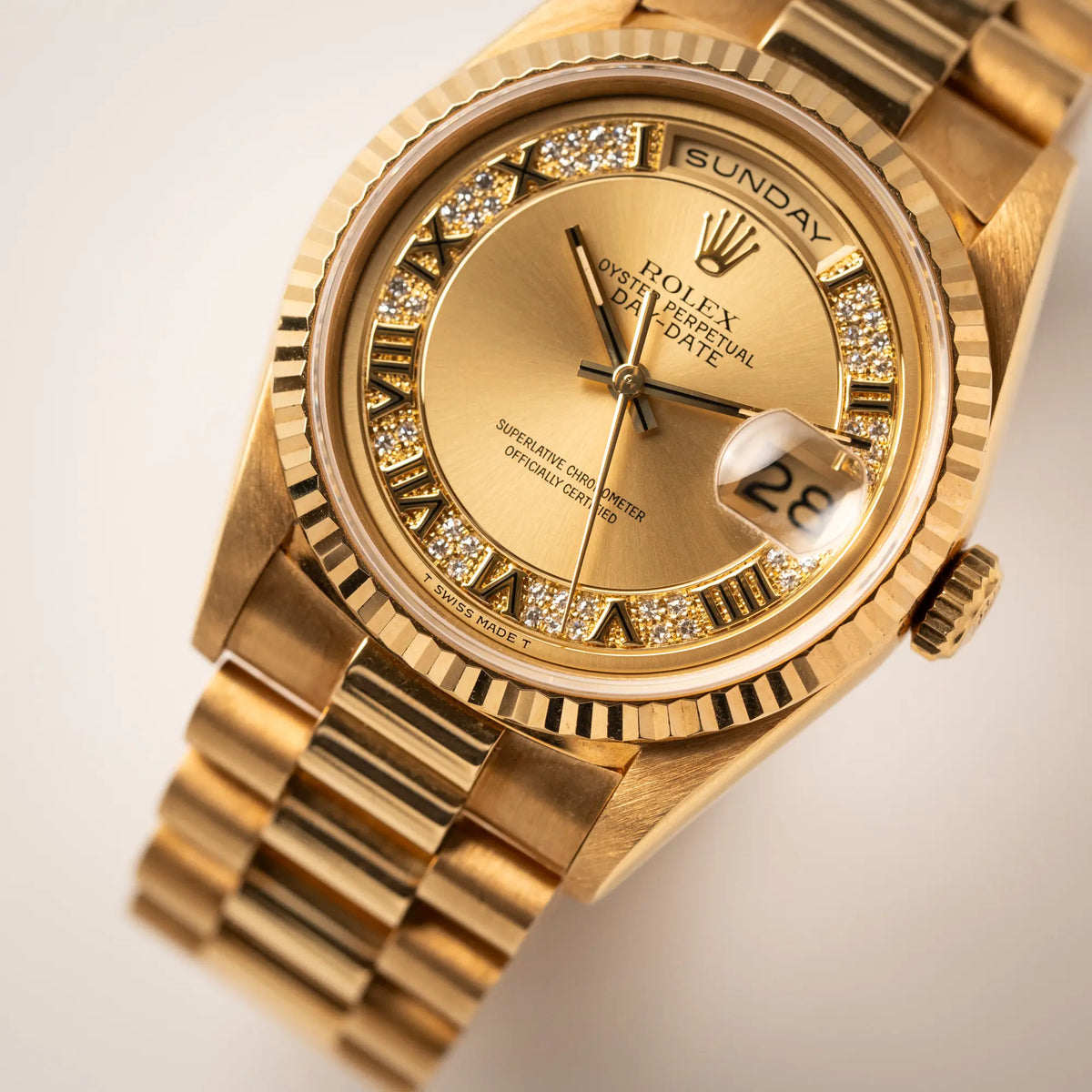 Detailaufnahme zeigt den Uhrenkopf der gelbgoldenen Rolex Day-Date 36 der Referenz 18238 mit einem seltenen Myriad-Dial mit Diamant-Kranz und römischen Indizes