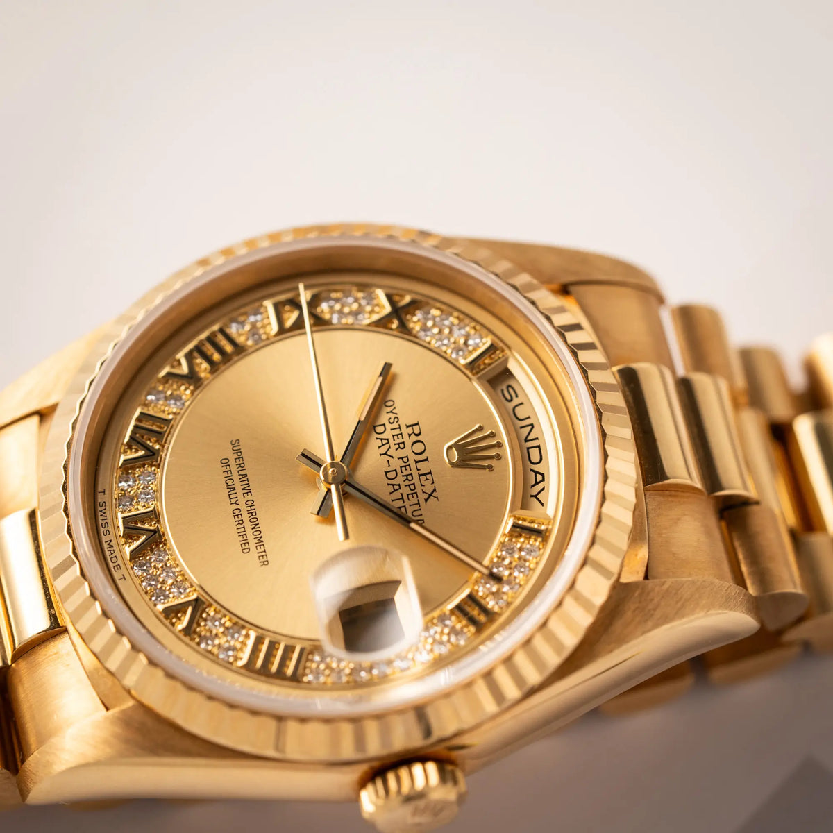 Detailaufnahme des Uhrenkopfes der gelbgoldenen Rolex Day-Date 36 der Referenz 18238 mit einem seltenen Myriad-Dial mit Diamant-Kranz und römischen Indizes