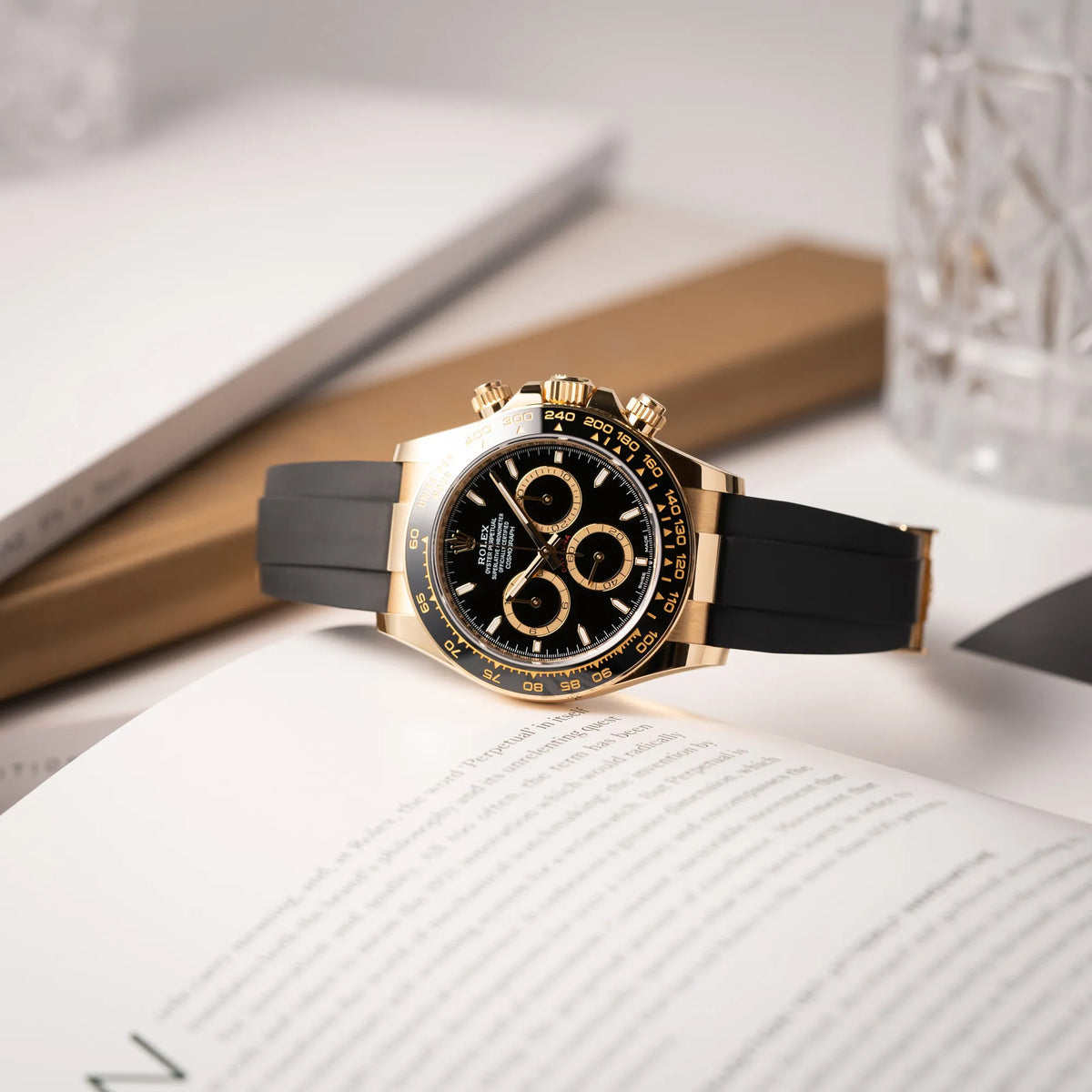 Produktfotografie der Rolex Daytona 126518LN mit Gelbgold-Gehäuse und schwarzem Zifferblatt am schwarzen Oysterflex-Armband aus Kautschuk