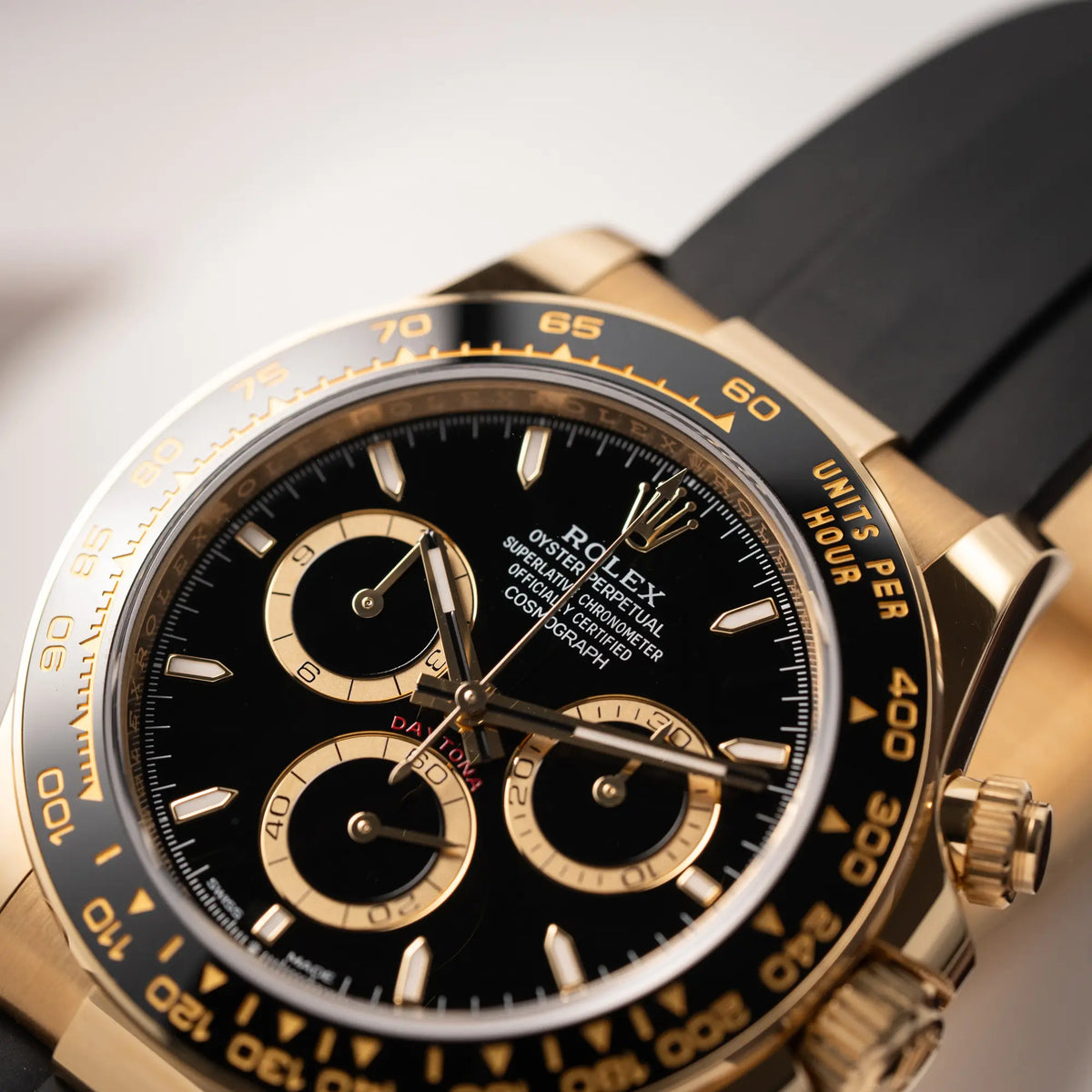 Detailaufnahme der Rolex Daytona 126518LN mit Gelbgold-Gehäuse und schwarzem Zifferblatt am schwarzen Oysterflex-Armband aus Kautschuk