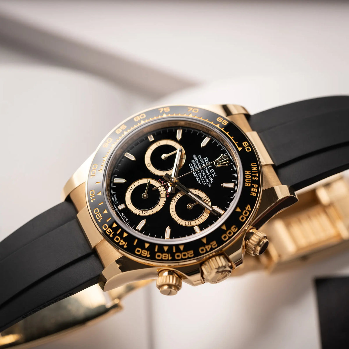 Produktfoto der "stehenden" Rolex Daytona 126518LN mit Gelbgold-Gehäuse und schwarzem Zifferblatt am schwarzen Oysterflex-Armband aus Kautschuk
