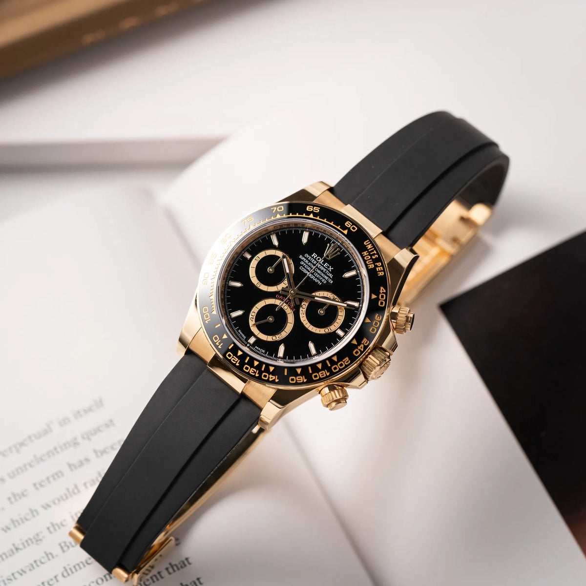 Produktfotografie der Rolex Daytona 126518LN mit Gelbgold-Gehäuse und schwarzem Zifferblatt am schwarzen Oysterflex-Armband aus Kautschuk