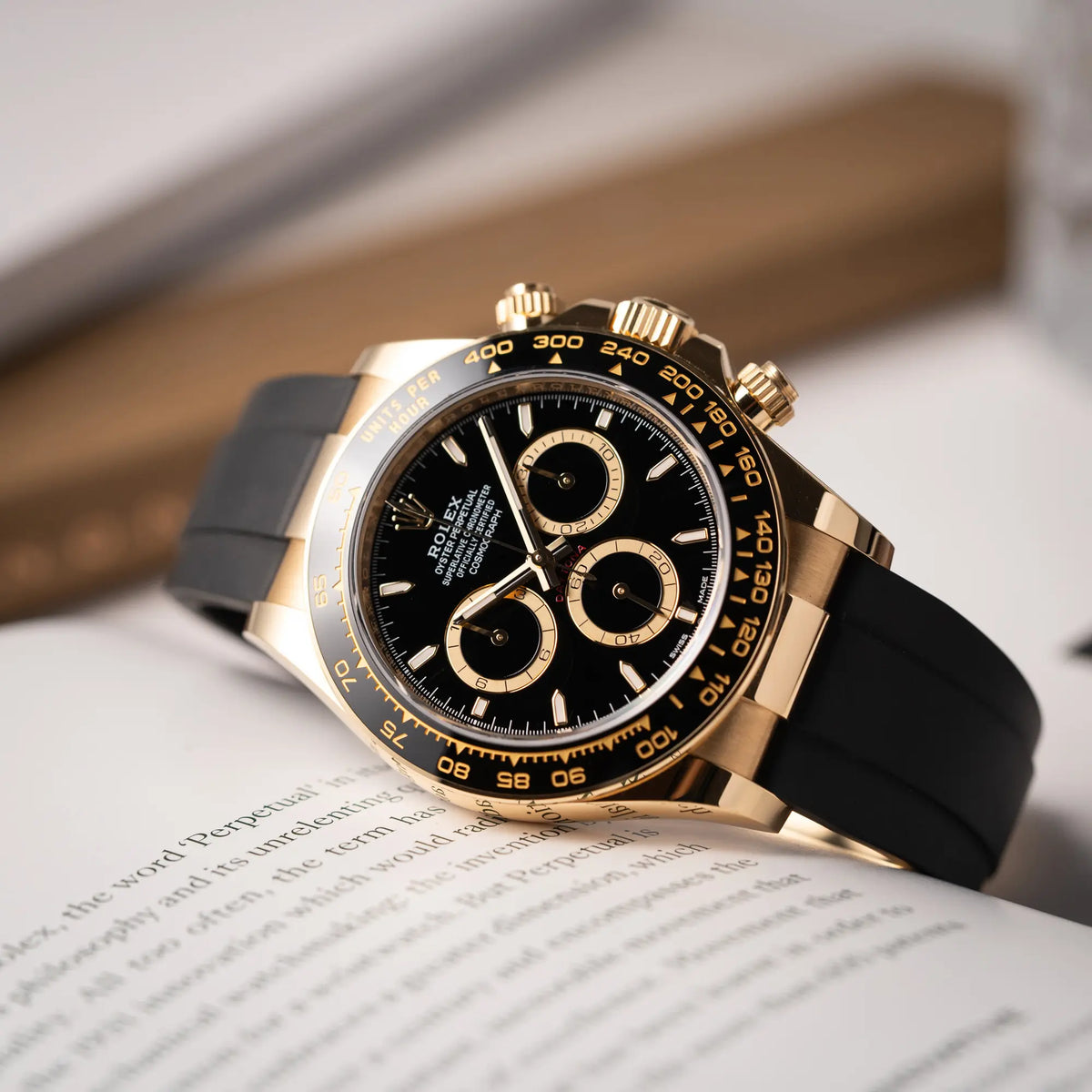 Nahe Produktfotografie der Rolex Daytona 126518LN mit Gelbgold-Gehäuse und schwarzem Zifferblatt am schwarzen Oysterflex-Armband aus Kautschuk