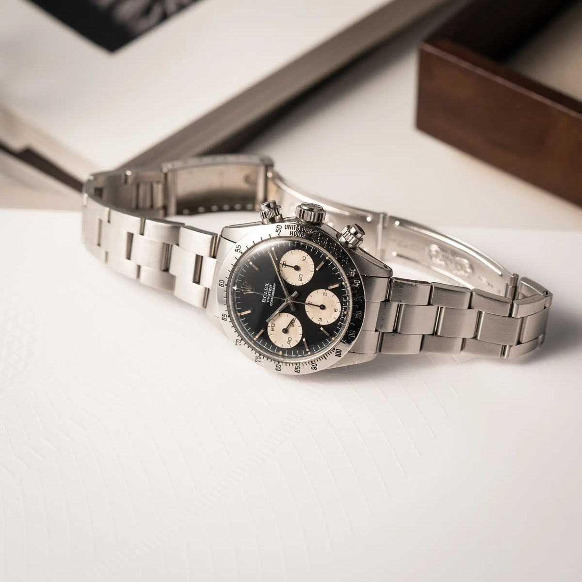 Rolex Daytona der Referenz 6265 mit Sigma-Dial in schwarz und weißen Sub-Dials im 37mm-Gehäuse aus den 70er Jahren liegt mit geöffneter Faltschliesse auf der seitlichen Gehäuseflanke