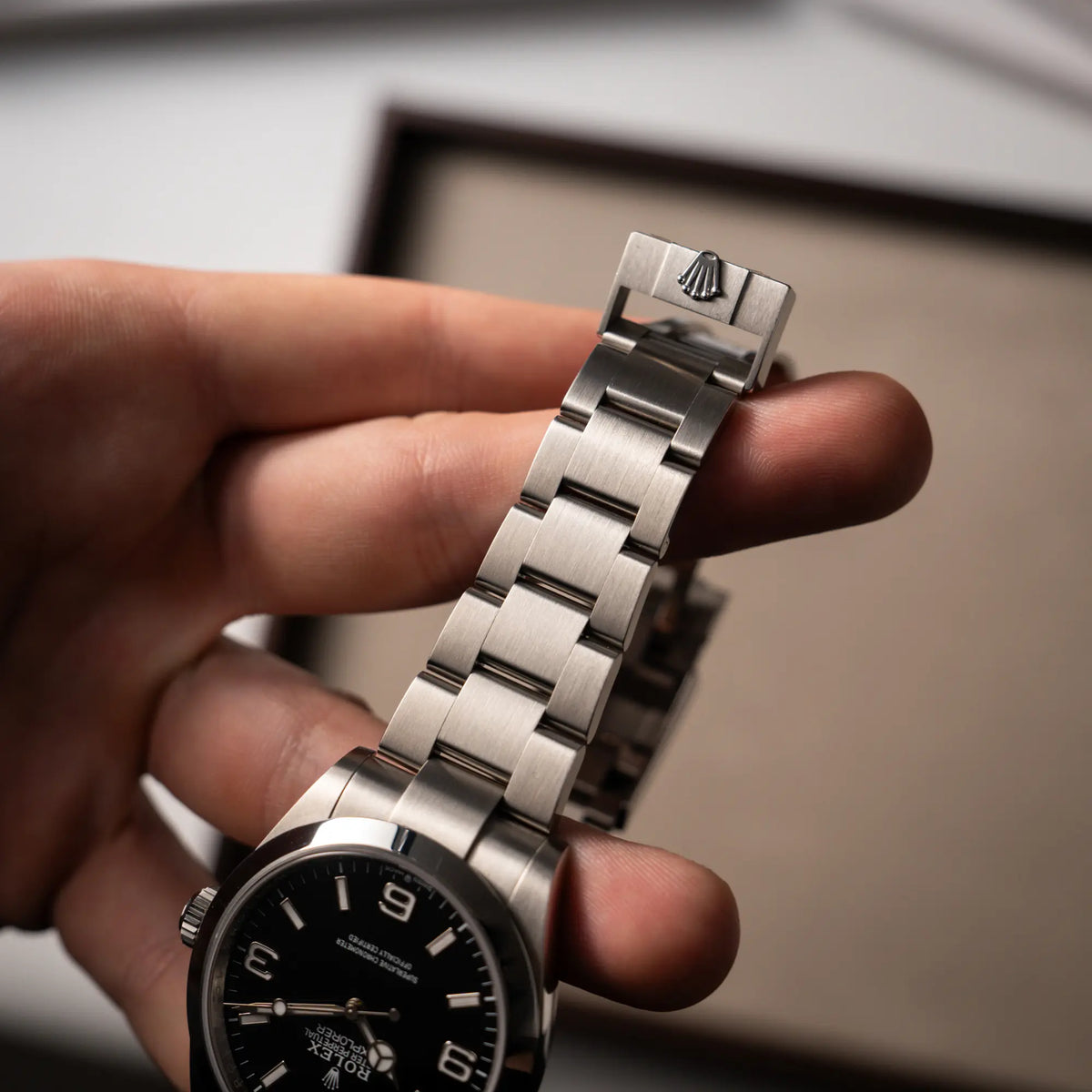 Mann hält die Rolex Explorer 40 Armbanduhr der Referenz 224270 mit dem klassischen 3-6-9-Explorer-Zifferblatt in seiner Hand und zeigt den Zustand des Oyster-Stahlbands