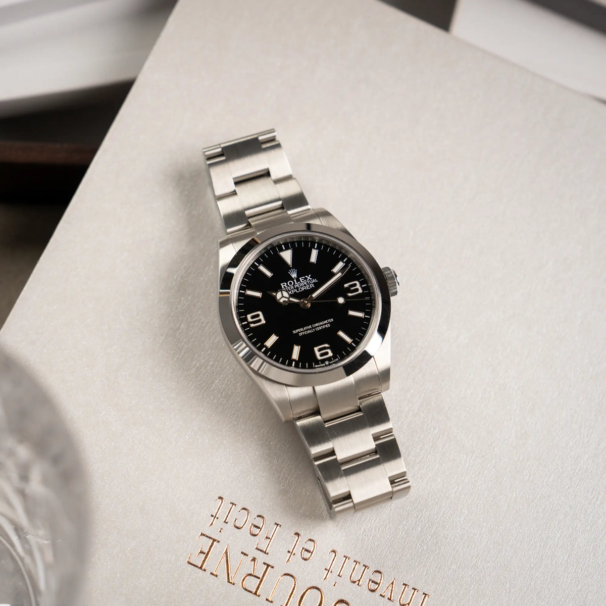 Produktfotografie der Rolex Explorer 40 Armbanduhr der Referenz 224270 mit dem klassischen 3-6-9-Explorer-Zifferblatt (Uhr liegt flach auf einem Nuch)
