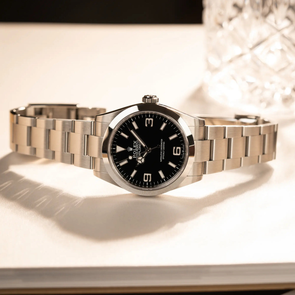 Produktfotografie der seitlich, bei 9 Uhr, auf der Gehäuseflanke liegenden Rolex Explorer 40 Armbanduhr der Referenz 224270 mit dem klassischen 3-6-9-Explorer-Zifferblatt