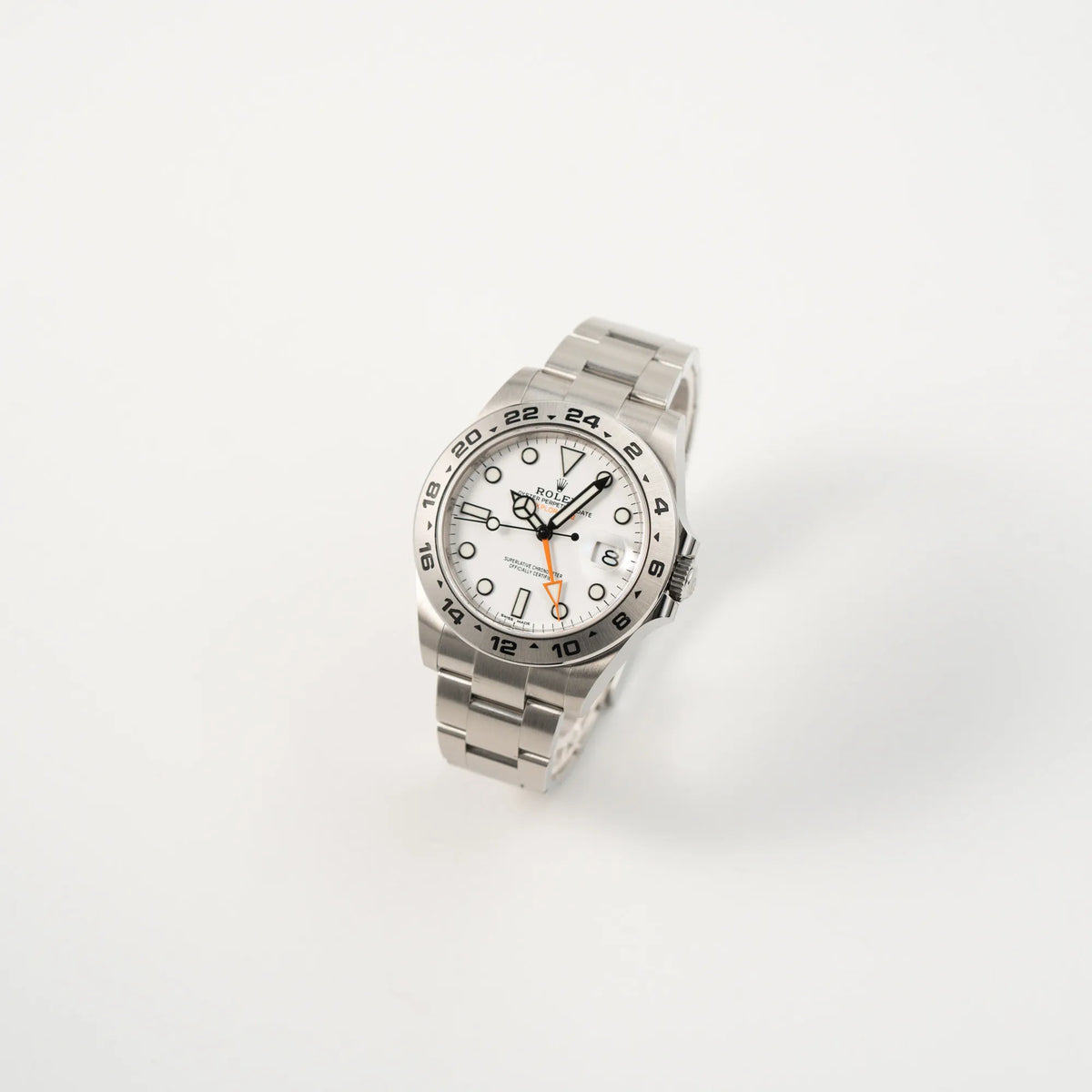 Leicht schräge Ansicht der Rolex Explorer II 216570 aus 2021 mit dem weißen Polar Zifferblatt mit dem typischen orangen GMT-Zeiger in einem sehr guten Zustand