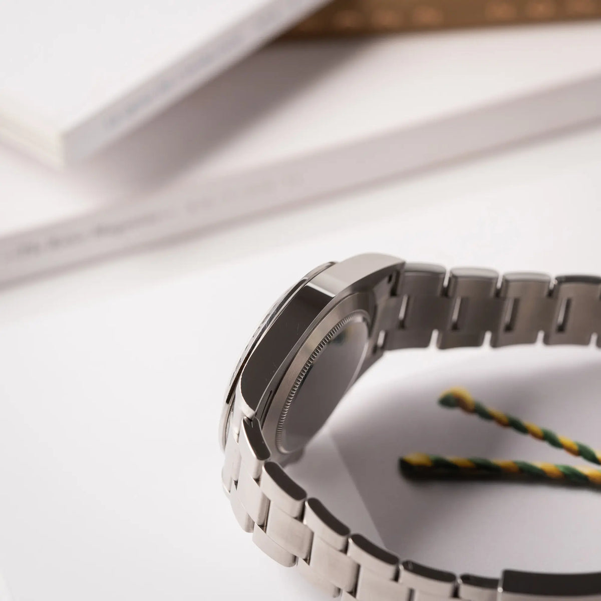 Produktfotografie zeigt die seitliche Gehäuseflanke der Rolex Explorer II der Referenz 226570 am Oyster-Stahlband mit dem weißen Polar-Zifferblatt und dem typischen orangen 24-Stunden-Zeiger