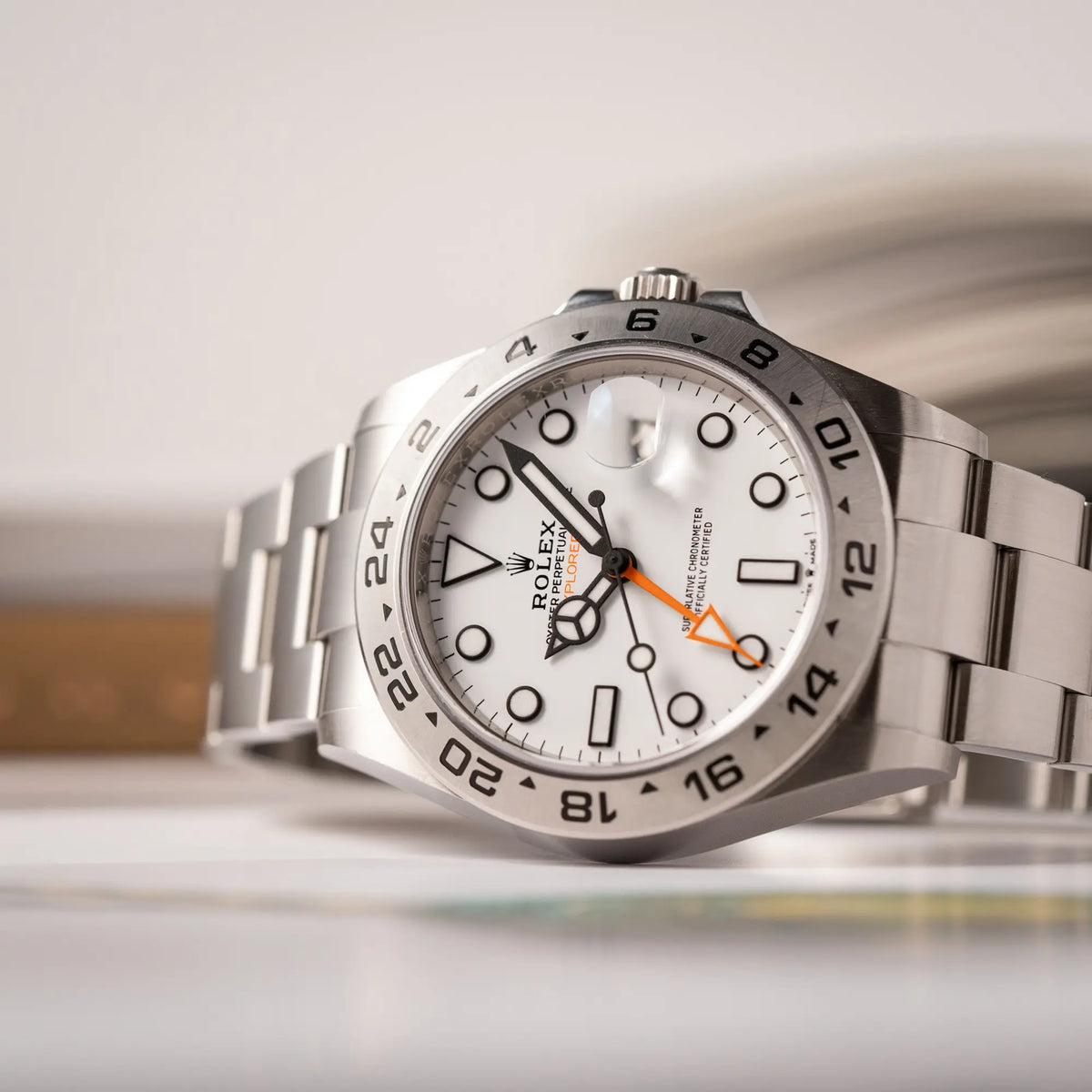 Produktfotografie als Titelbild für die Rolex Explorer II der Referenz 226570 am Oyster-Stahlband mit dem weißen Polar-Zifferblatt und dem typischen orangen 24-Stunden-Zeiger
