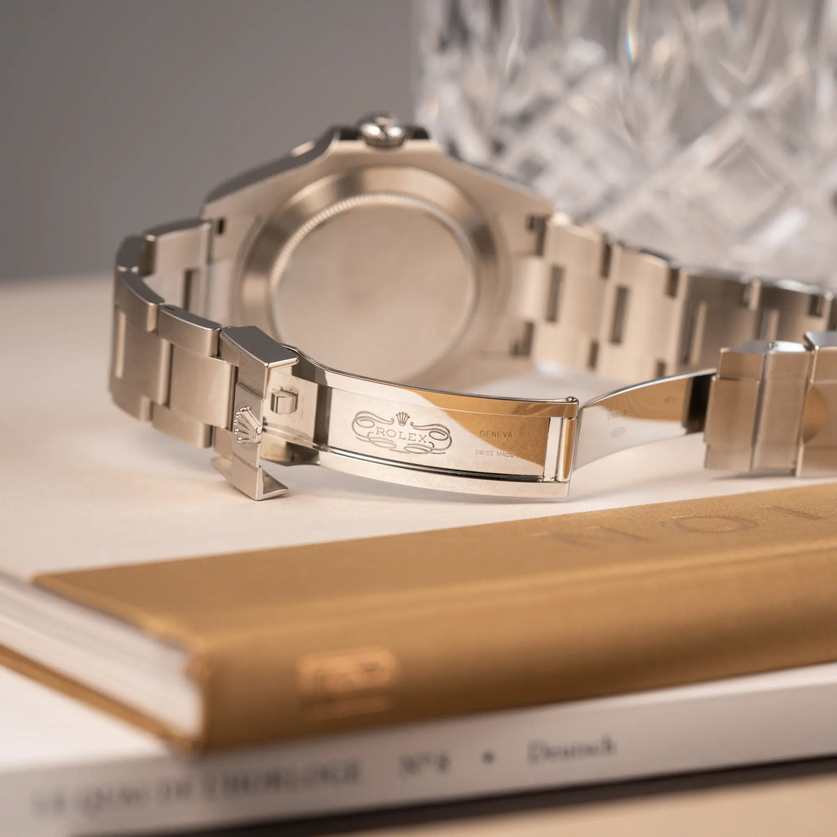 Produktfotografie der Rolex Explorer 2 der Referenz 226570 mit dem Polar Zifferblatt und orangem GMT-Zeiger zeigt das klassische Rolex Logo im Inneren der Oyster-Faltschliesse