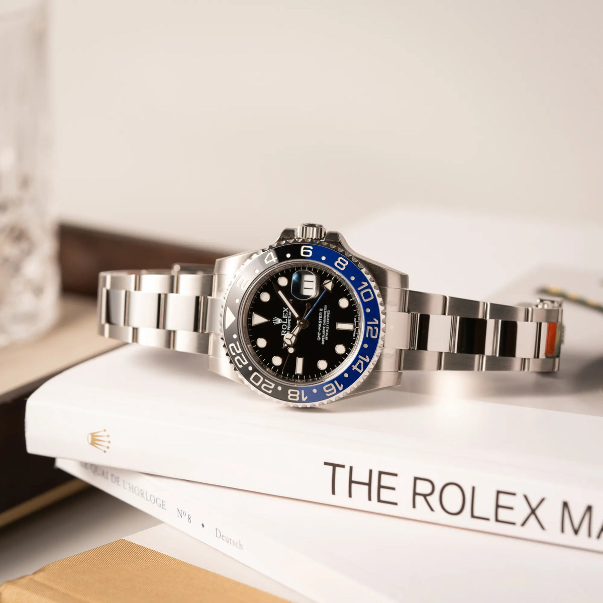 Produktfotografie der Rolex GMT-Master II der Referenz 116710BLNR mit dem Nickname "Batman" mit der schwarz blauen Keramik-Lünette am Oyster-Stahlband im verklebten Neuzustand