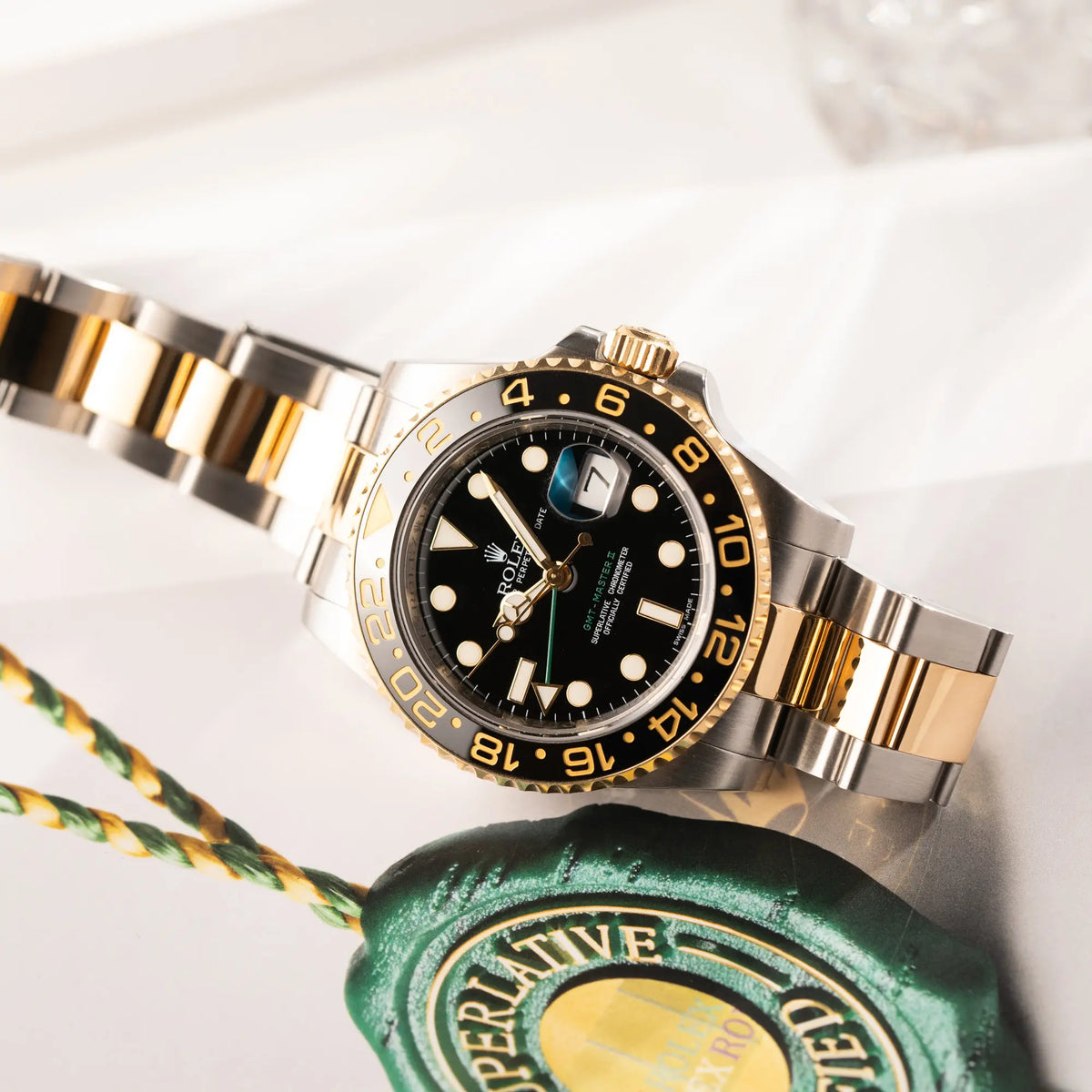 Produktfotografie der Rolex GMT-Master II der Referenz 116713LN in Stahl-Gold mit schwarzem Zifferblatt und dem grünen GMT-Zeiger