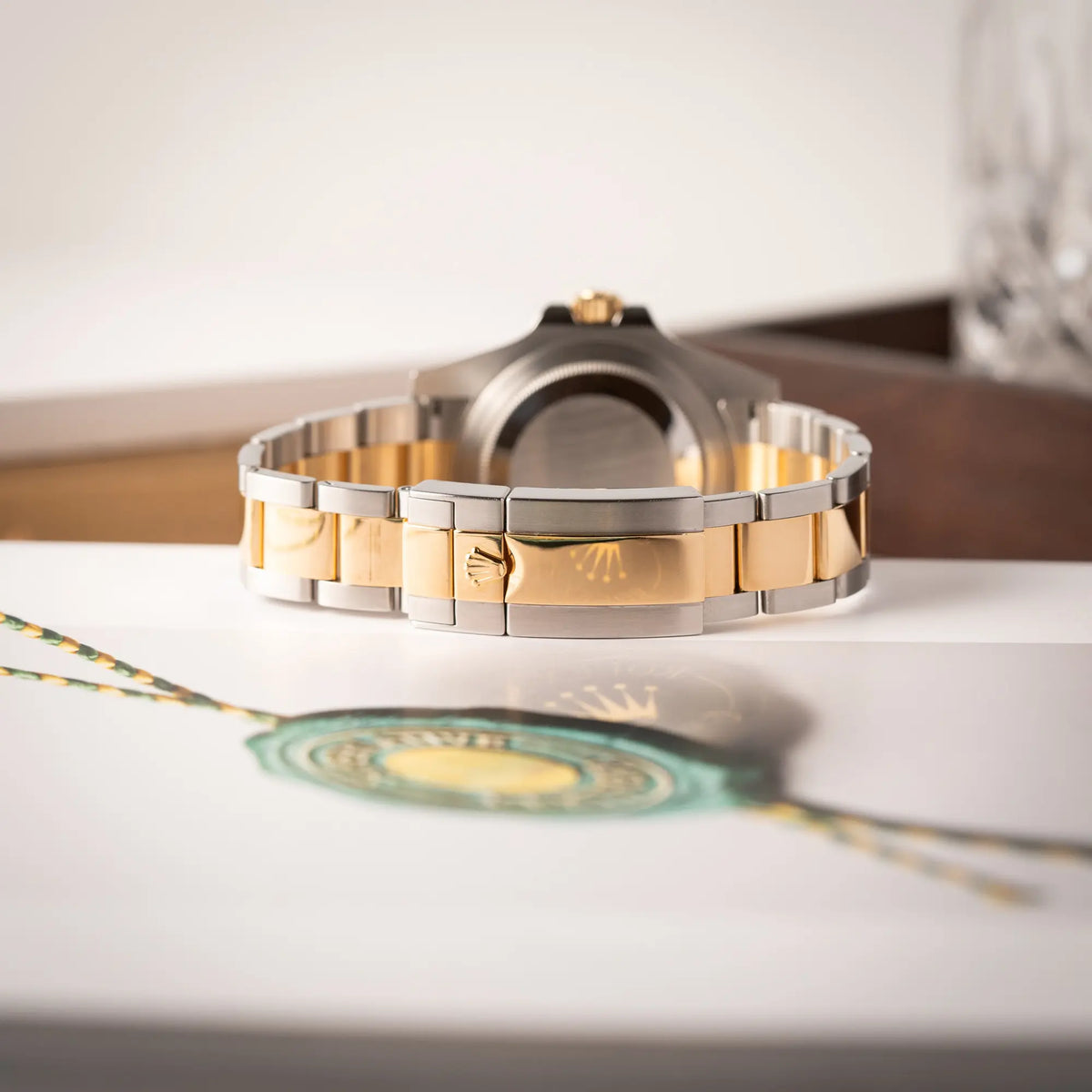 Produktfoto zeigt das stahl-goldene Oyster-Armband der Rolex GMT-Master II der Referenz 116713LN in Stahl-Gold mit schwarzem Zifferblatt und dem grünen GMT-Zeiger