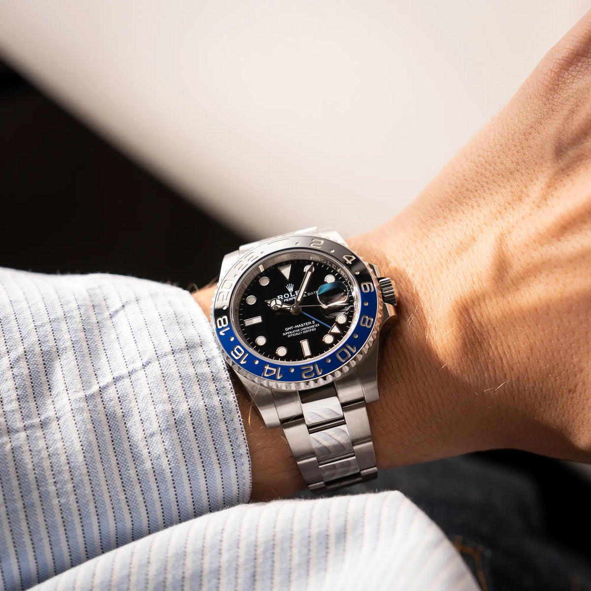 Mann trägt die Rolex GMT-Master II 126710BLNR mit dem Nickname Batman und der typischen Kombination aus blau-schwarzer Keramik-Lünette und schwarzem Zifferblatt für einen Wristshot an seinem Handgelenk