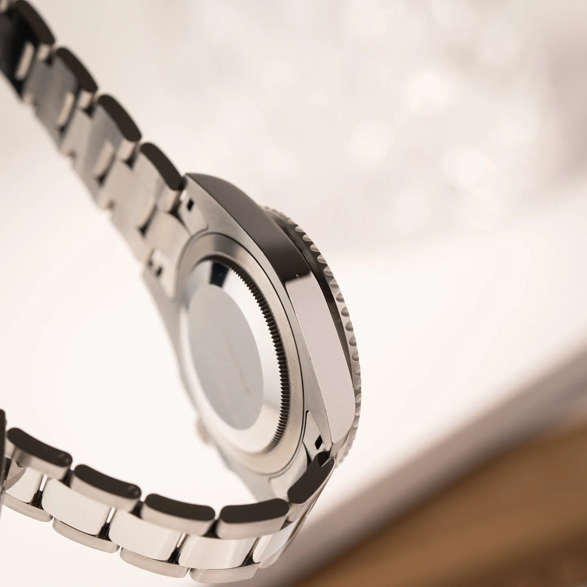 Produktfotografie der seitlichen Gehäuseflanke und des Gehäusebodens der Rolex GMT-Master II 126710BLNR mit dem Nickname Batman und der typischen Kombination aus blau-schwarzer Keramik-Lünette und schwarzem Zifferblatt