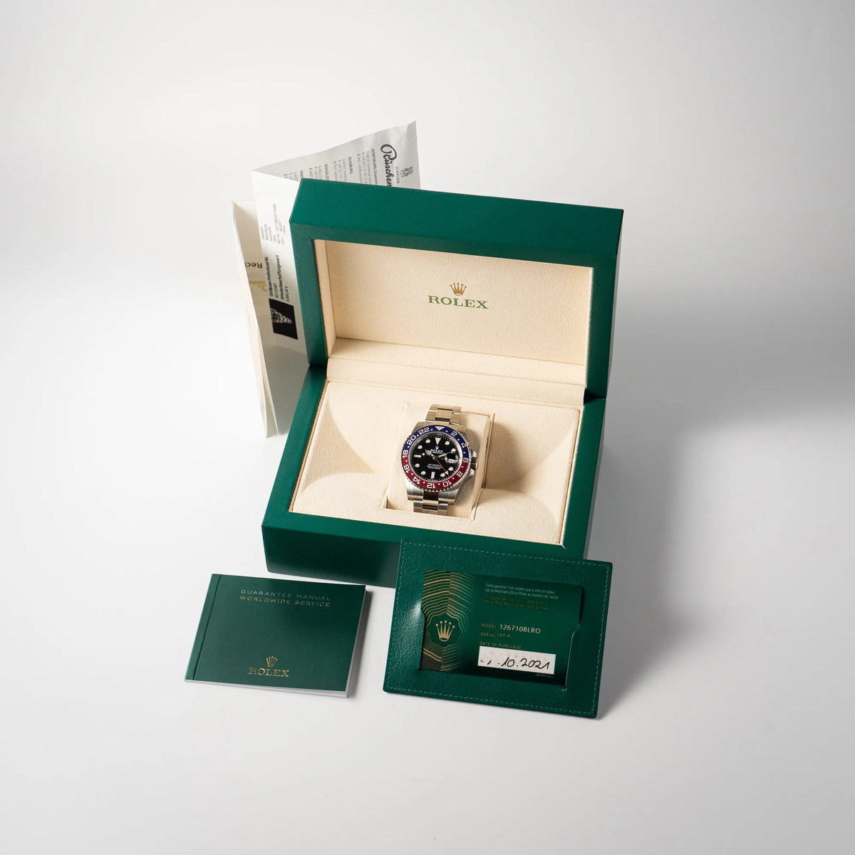 Lieferumfang zu der Rolex GMT-Master II der Referenz 126710BLRO mit der blau-roten Pepsi-Lünette in Keramik am Oyster-Stahl-Armband im ungetragenen Zustand, bestehend aus Box, originalen Papieren und Booklet, sowie Rüschenbeck-Beleg