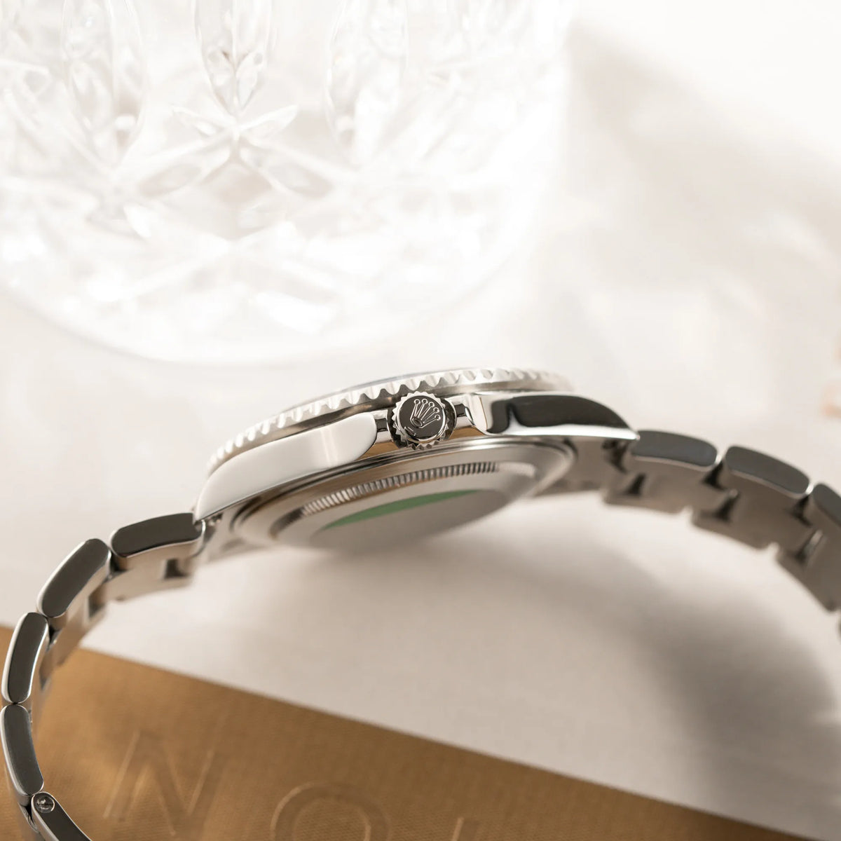 Produktfotografie der Rolex GMT-Master II 16710 mit der schwarz-roten "Coke" Aluminium-Lünetten-Einlage aus 2003 am Oyster Stahlband zeigt die Aufzugskrone