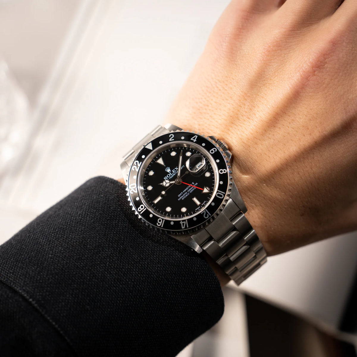 Mann trägt die Rolex GMT-Master II 16710 aus 2001 mit schwarzem Aluminium-Lünetten-Inlay in einem neuwertigen Zustand an seinem handgelenk