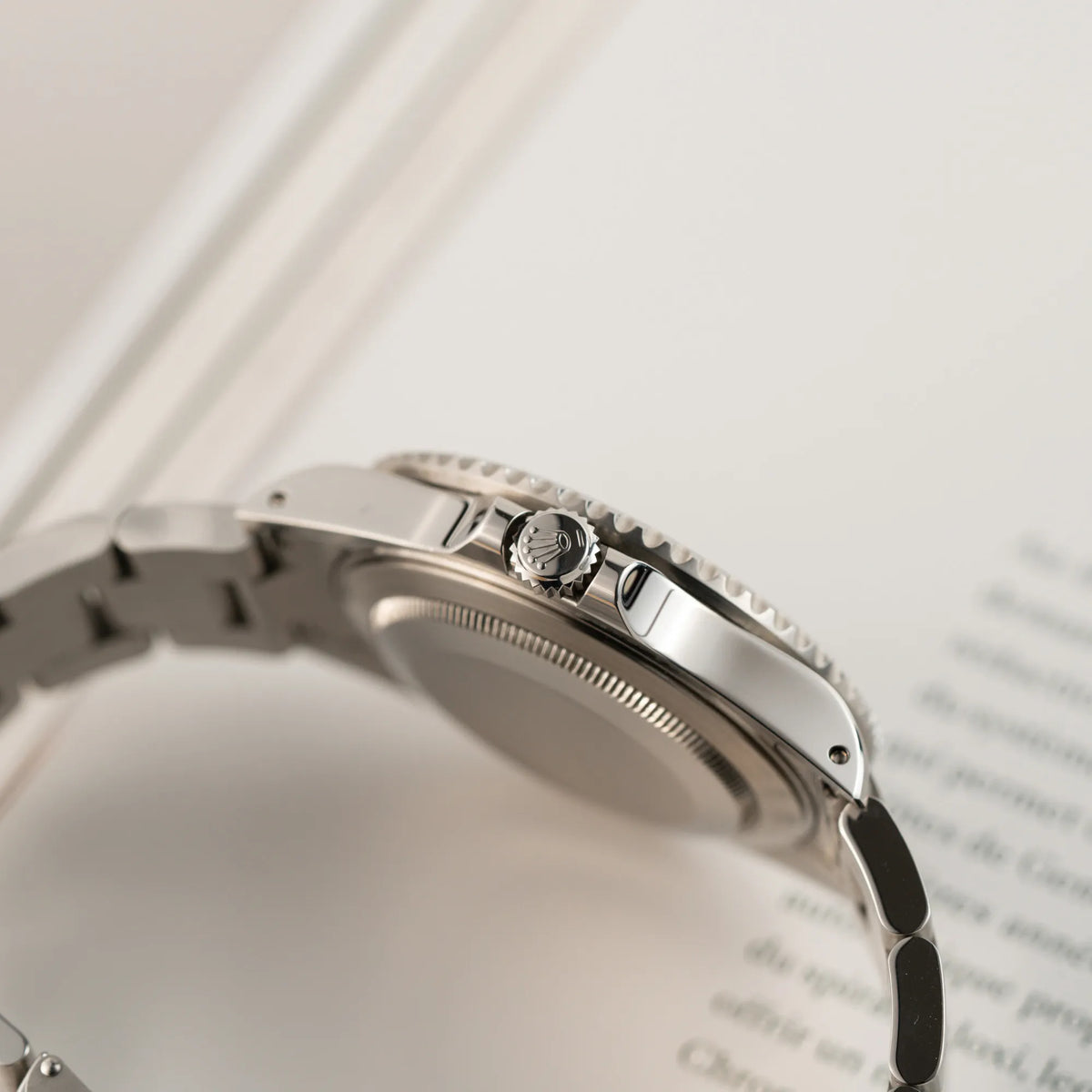 Produktfotografie zeigt die Aufzugskrone der Rolex GMT-Master II 16710 aus 2001 mit schwarzem Aluminium-Lünetten-Inlay in einem neuwertigen Zustand