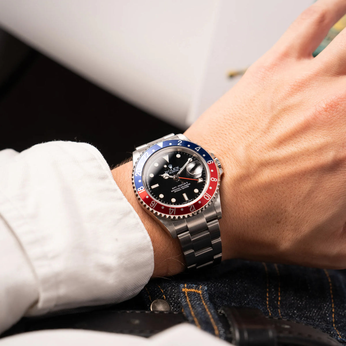 Mann trägt die Rolex GMT-Master II der Referenz 16710 mit der blau-roten Pepsi Lünette aus Aluminium mit kräftigen Farben für einen Wirstshot an seinem Handgelenk
